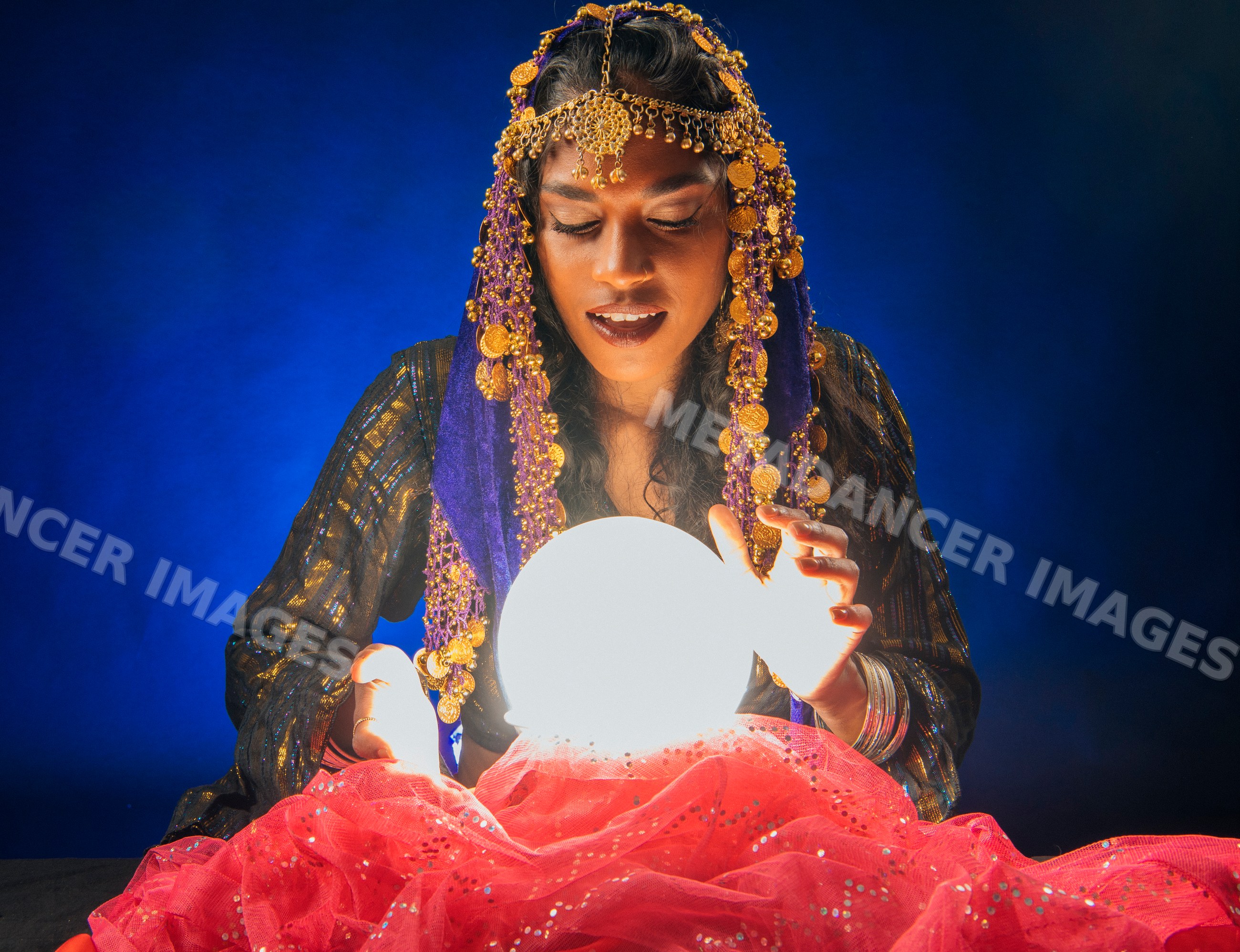 A fortune teller gazes into a glowing crystal ball