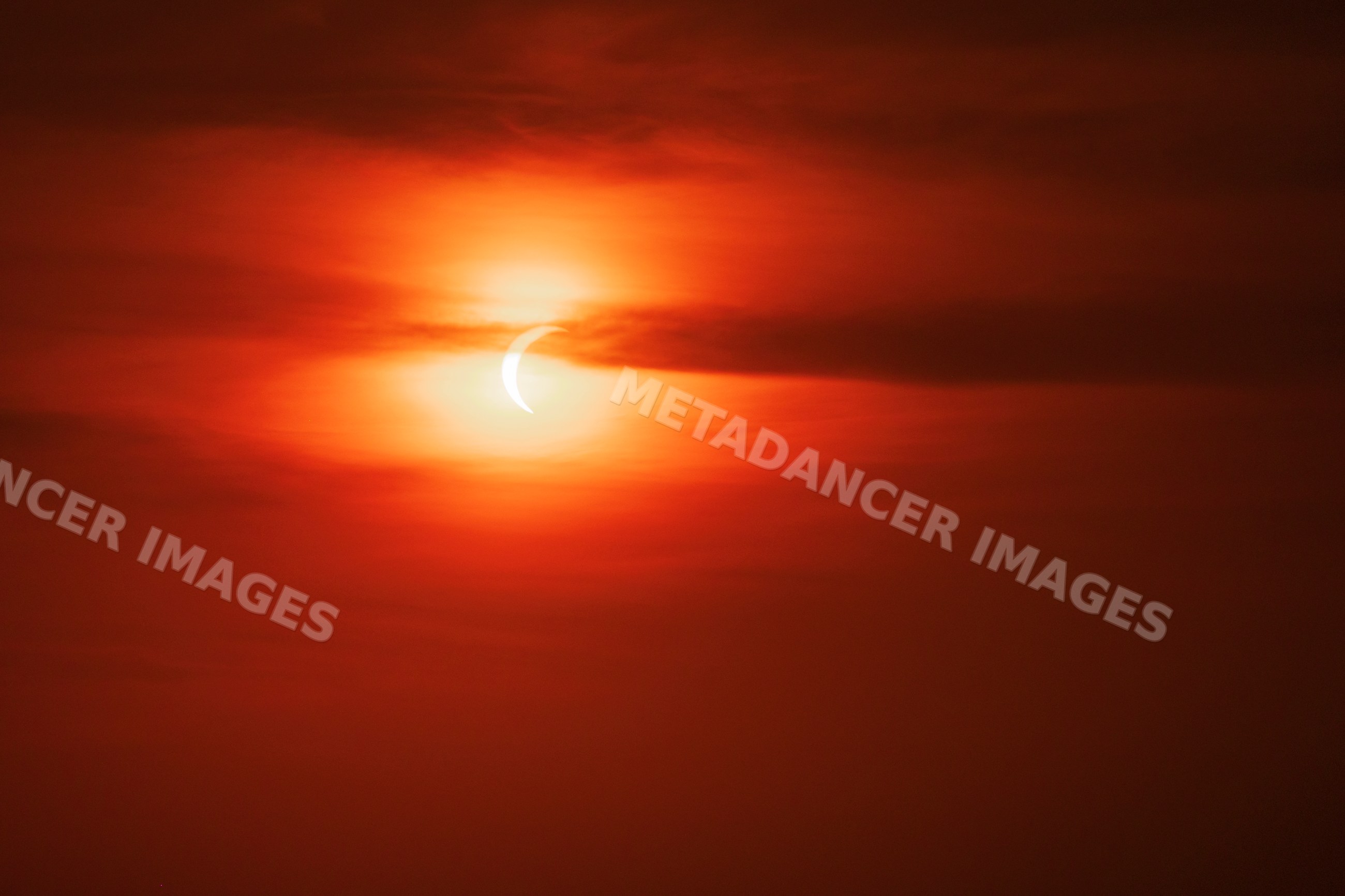 Solar eclipse over red morning sky in valldemossa Mallorca