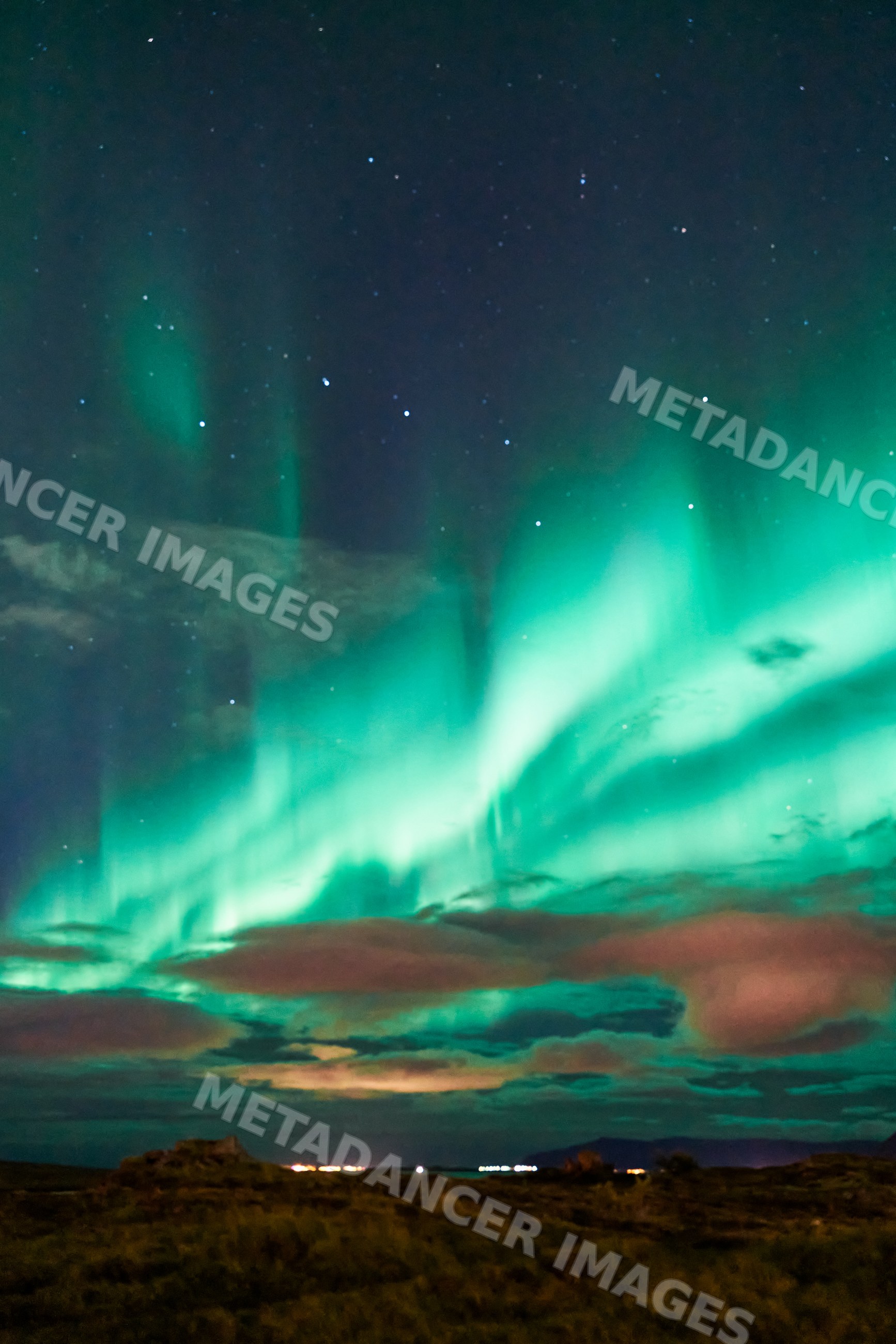 The northern lights illuminate the starry sky over Iceland landscape