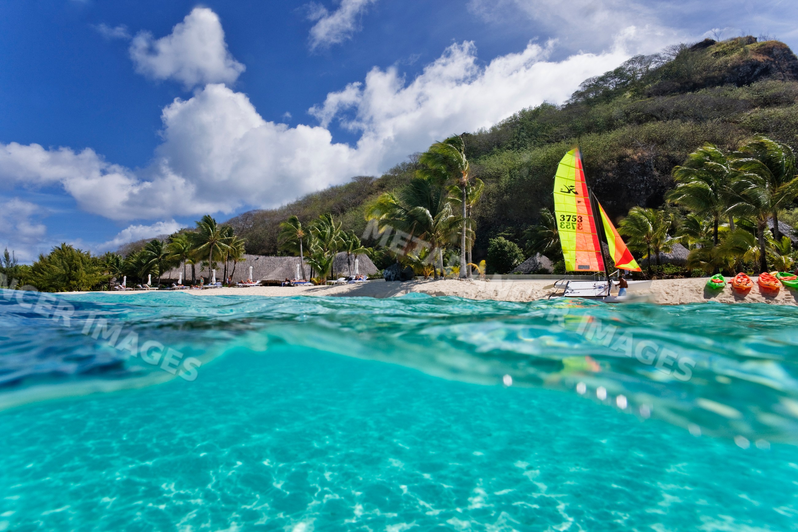 Sailboat and kayaks on tropical beach
