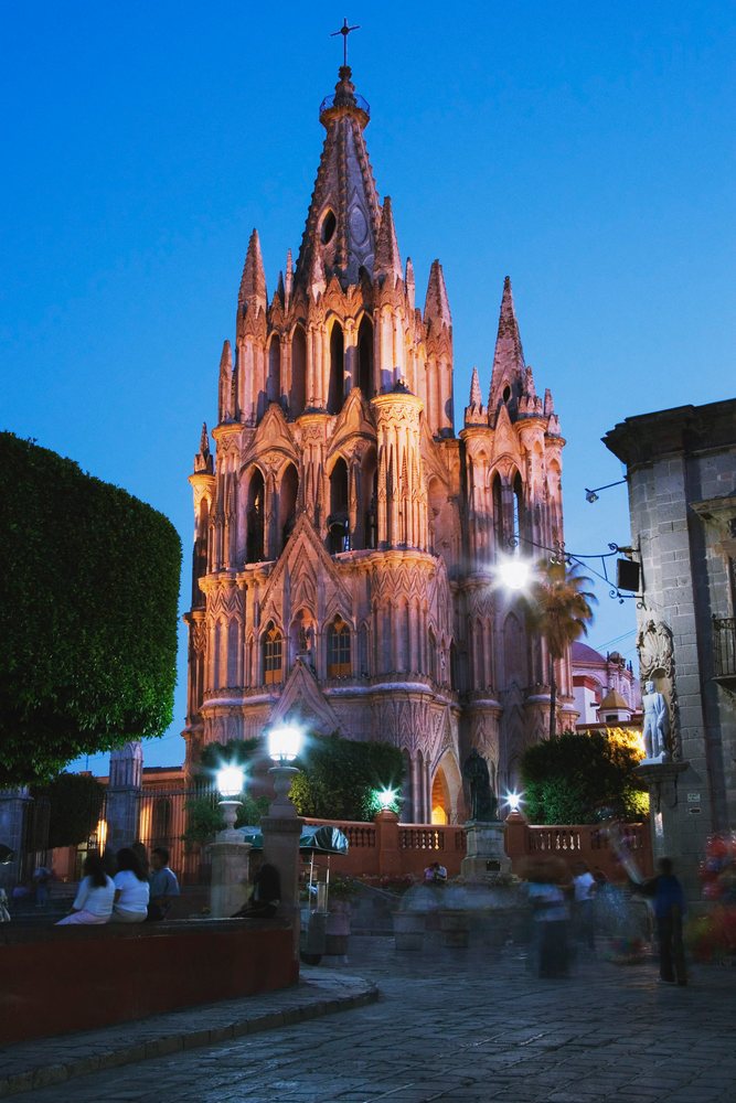 Gothic-style church illuminated at evening plaza