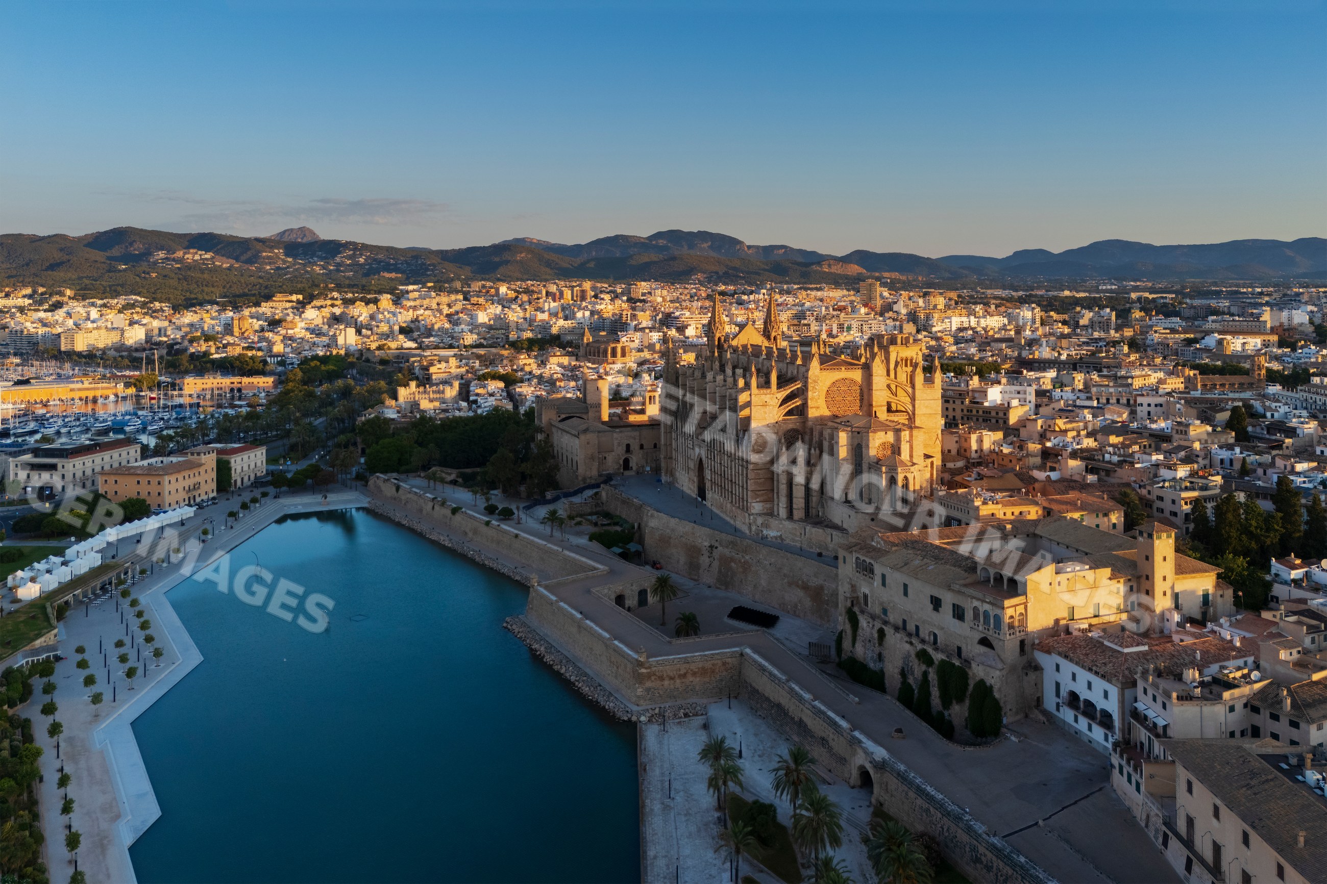 Cathedral in Palma de Mallorca with harbor and cityscape at sunset