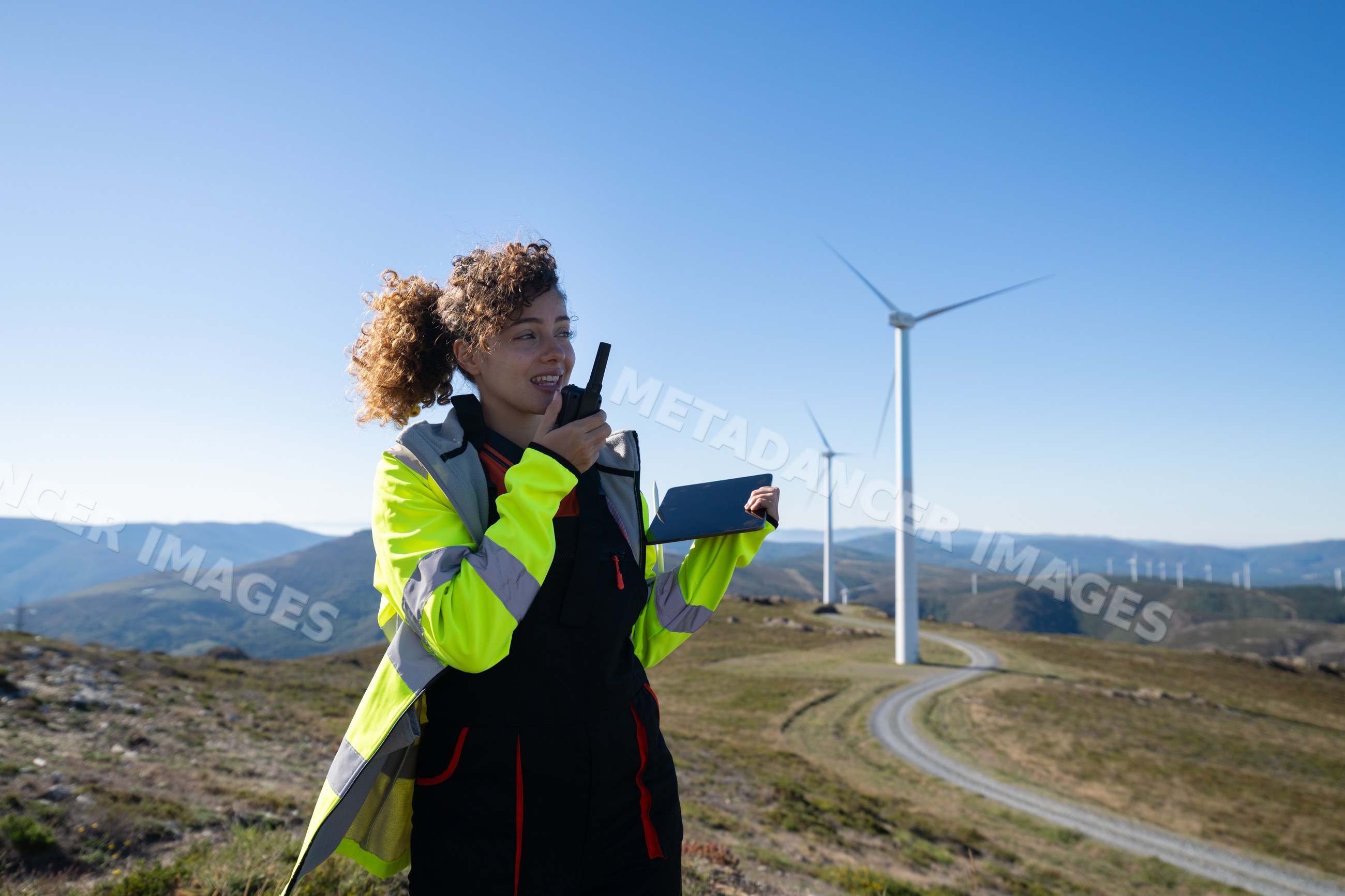 White woman monitoring wind turbines at wind farm in Galicia Spain