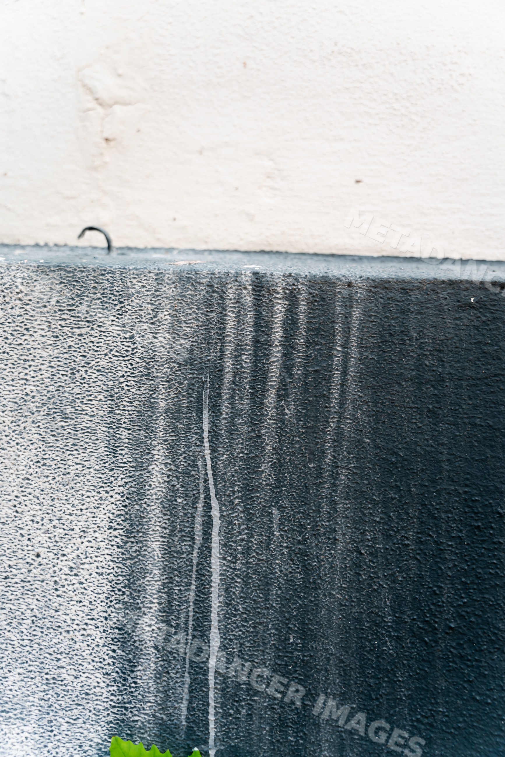 Exterior wall with weathered black and white textured paint