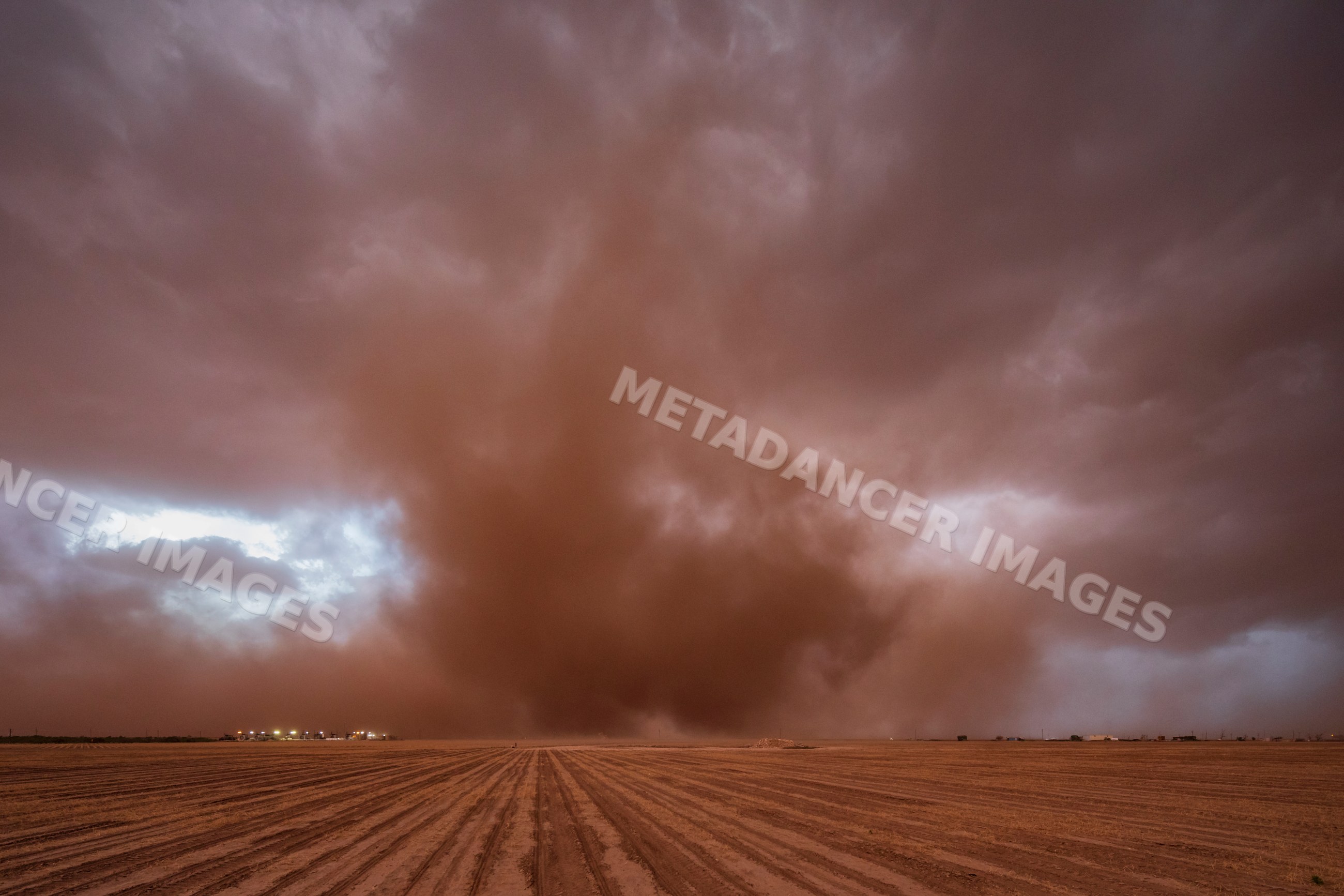 Supercell storm with dust cloud over open field