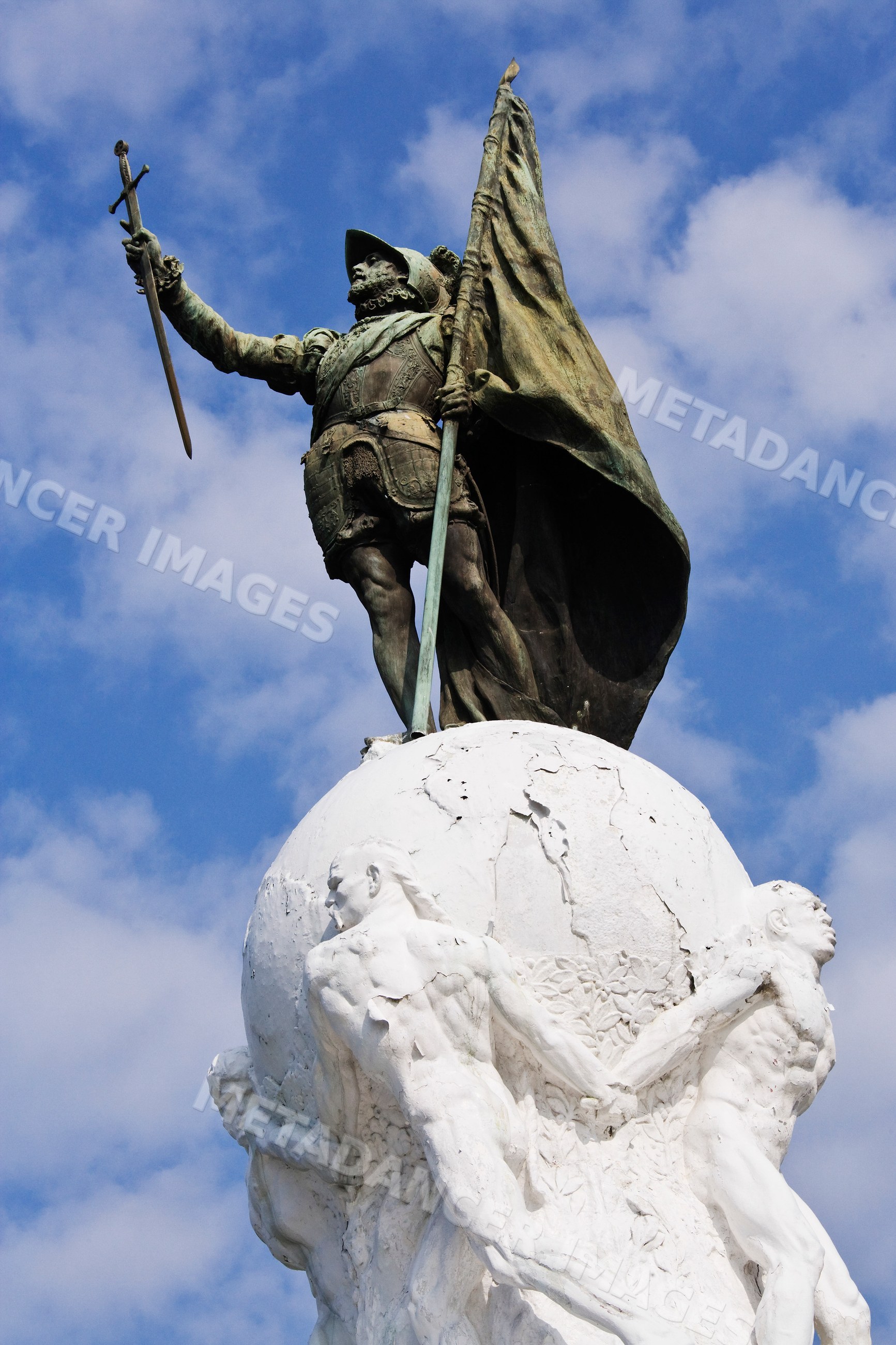 Statue of vasco nunez de balboa holding sword and flag outdoors