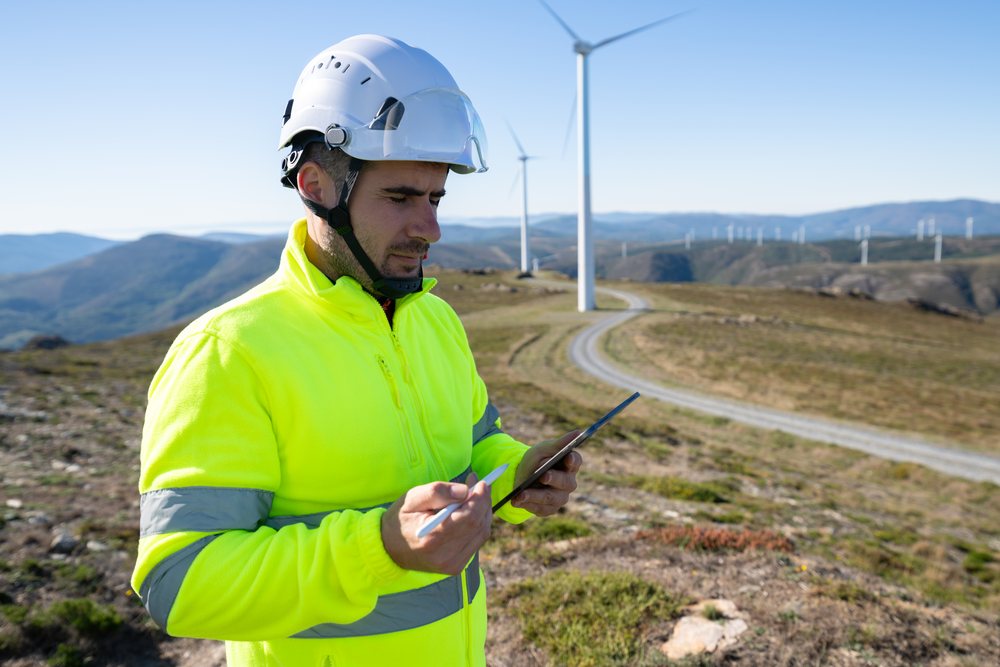 White worker using tablet at wind farm in Galicia Spain