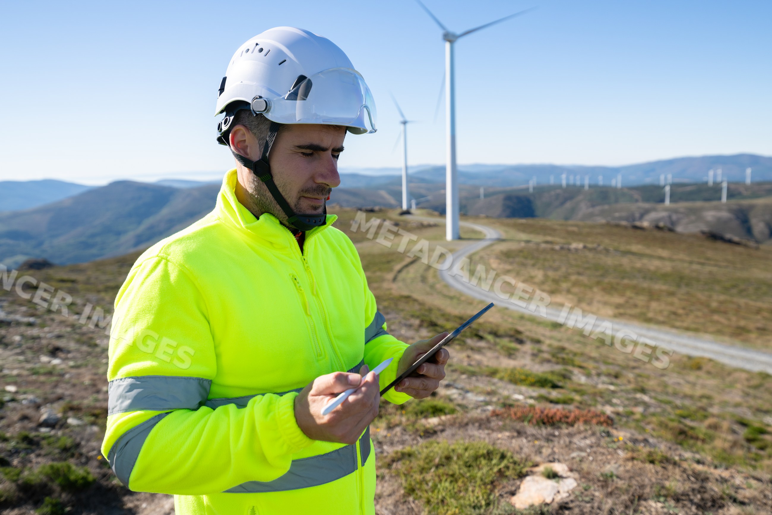 White worker using tablet at wind farm in Galicia Spain