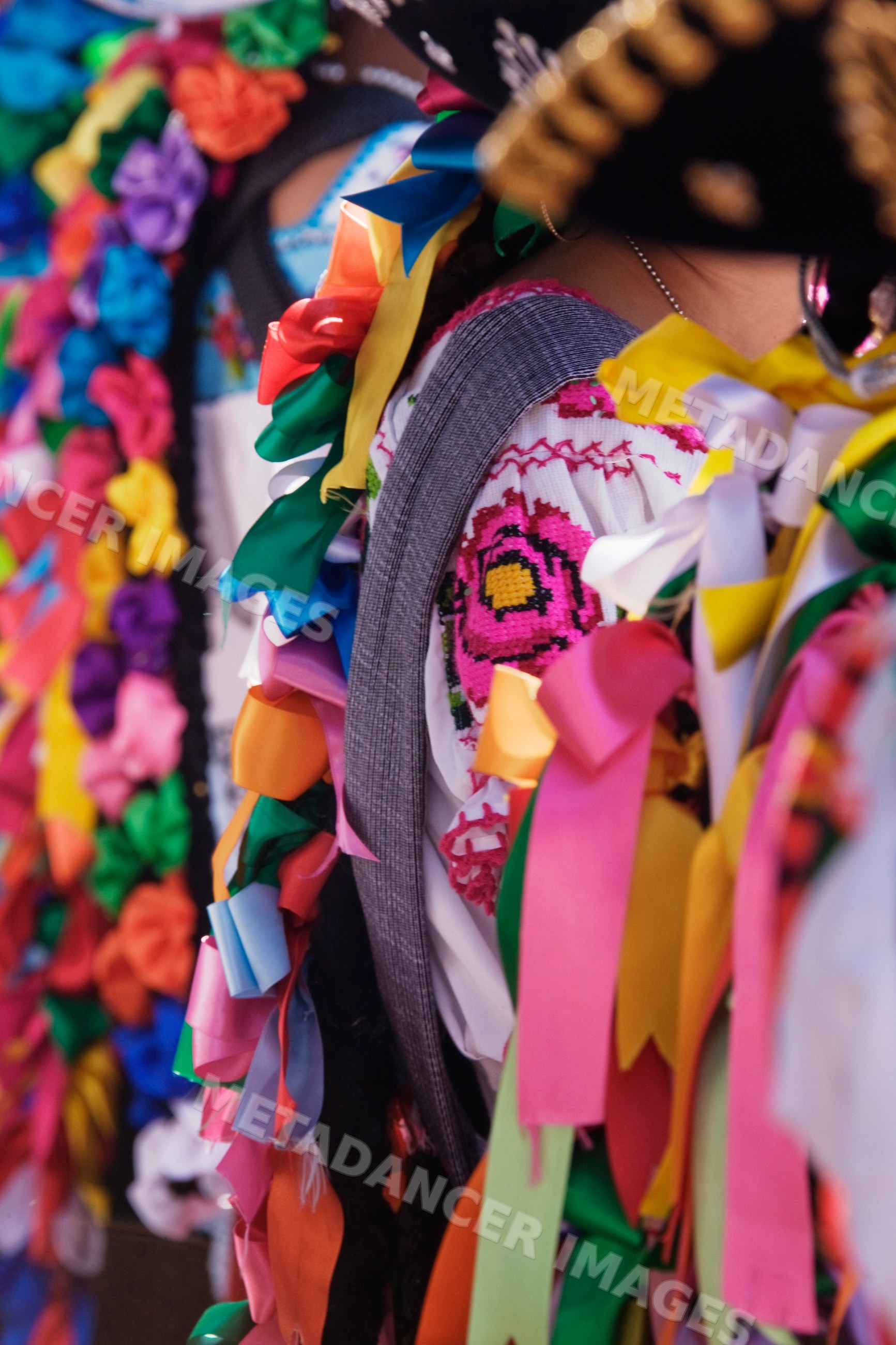 Colorful ribbons and embroidered textiles adorn a folk dress
