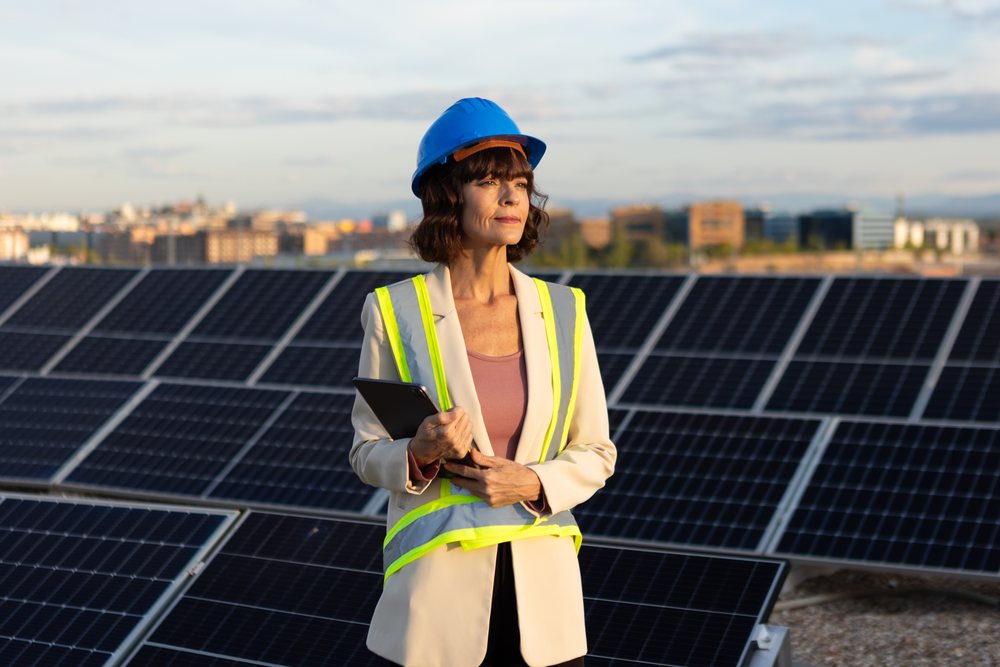 White woman engineer inspecting solar panels at solar energy site