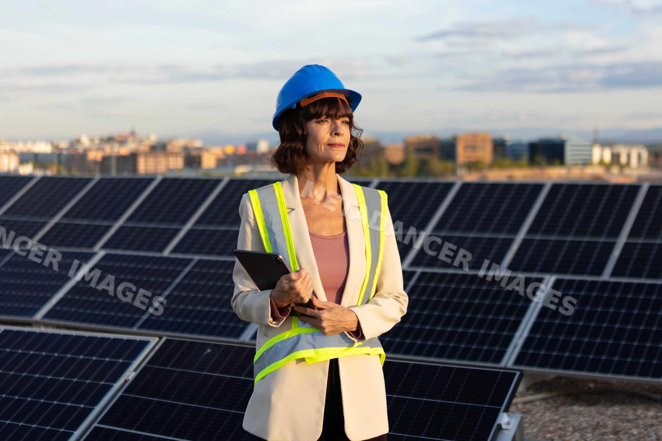 White woman engineer inspecting solar panels at solar energy site