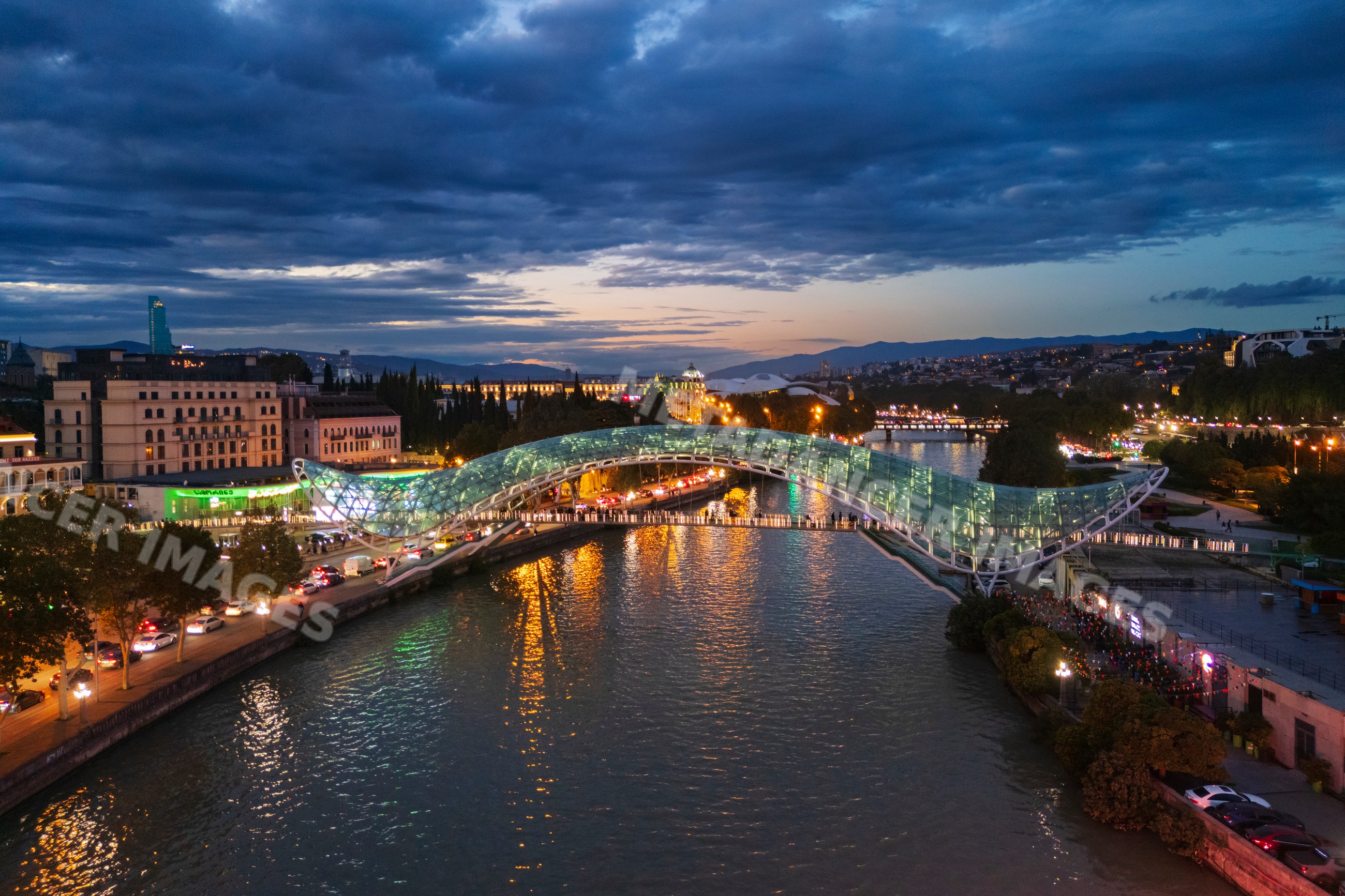 The bridge of peace illuminated over the mtkvari river at Dusk