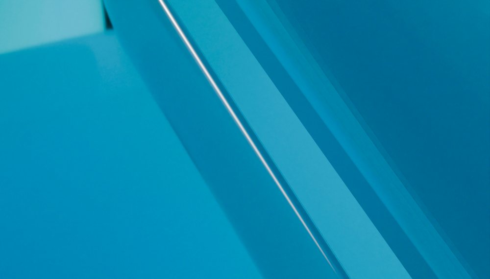 Close-up of layered blue glass showing abstract geometric reflections