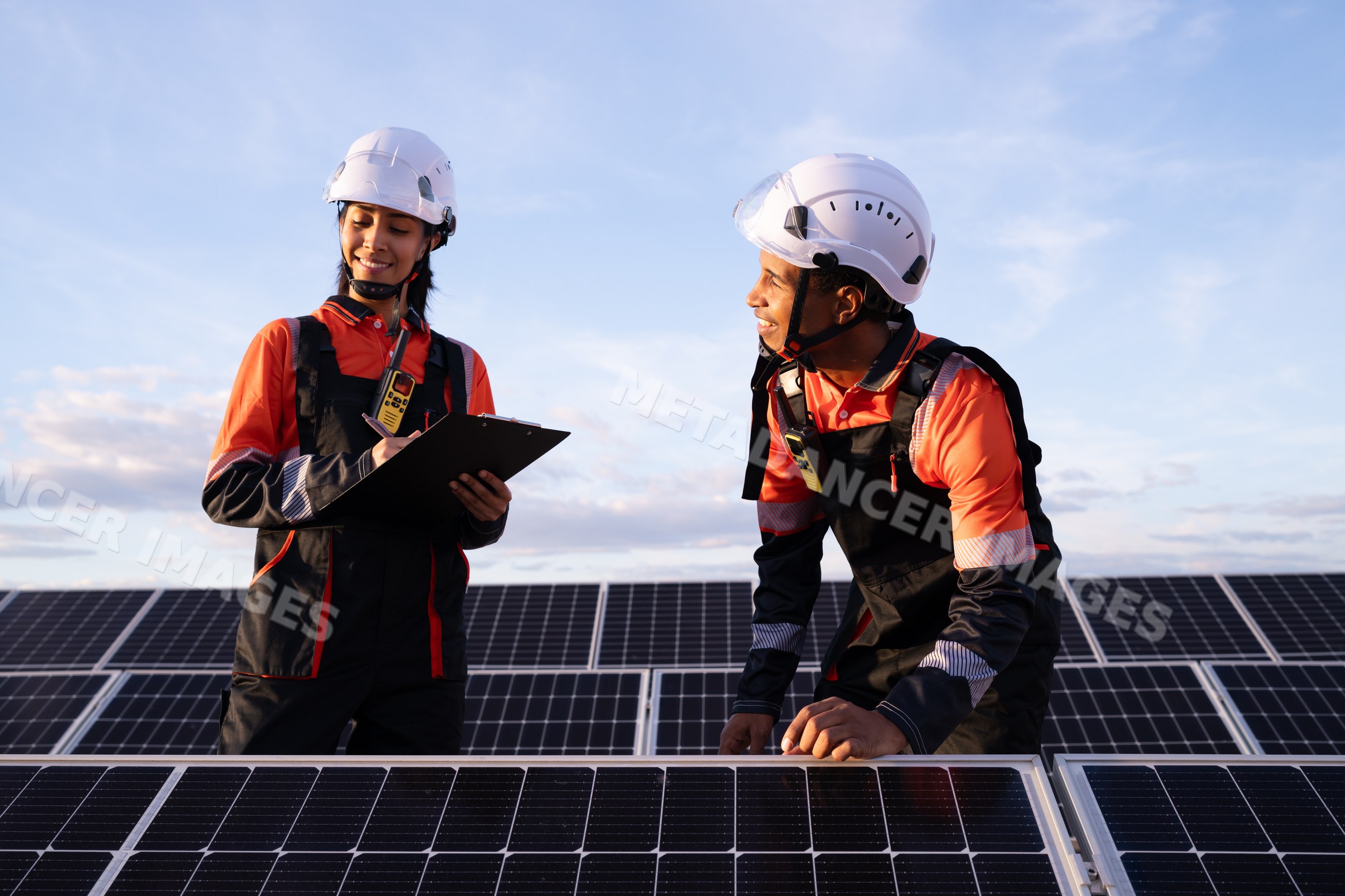 Engineers inspect solar panels outdoors at sunset in Madrid, Spain