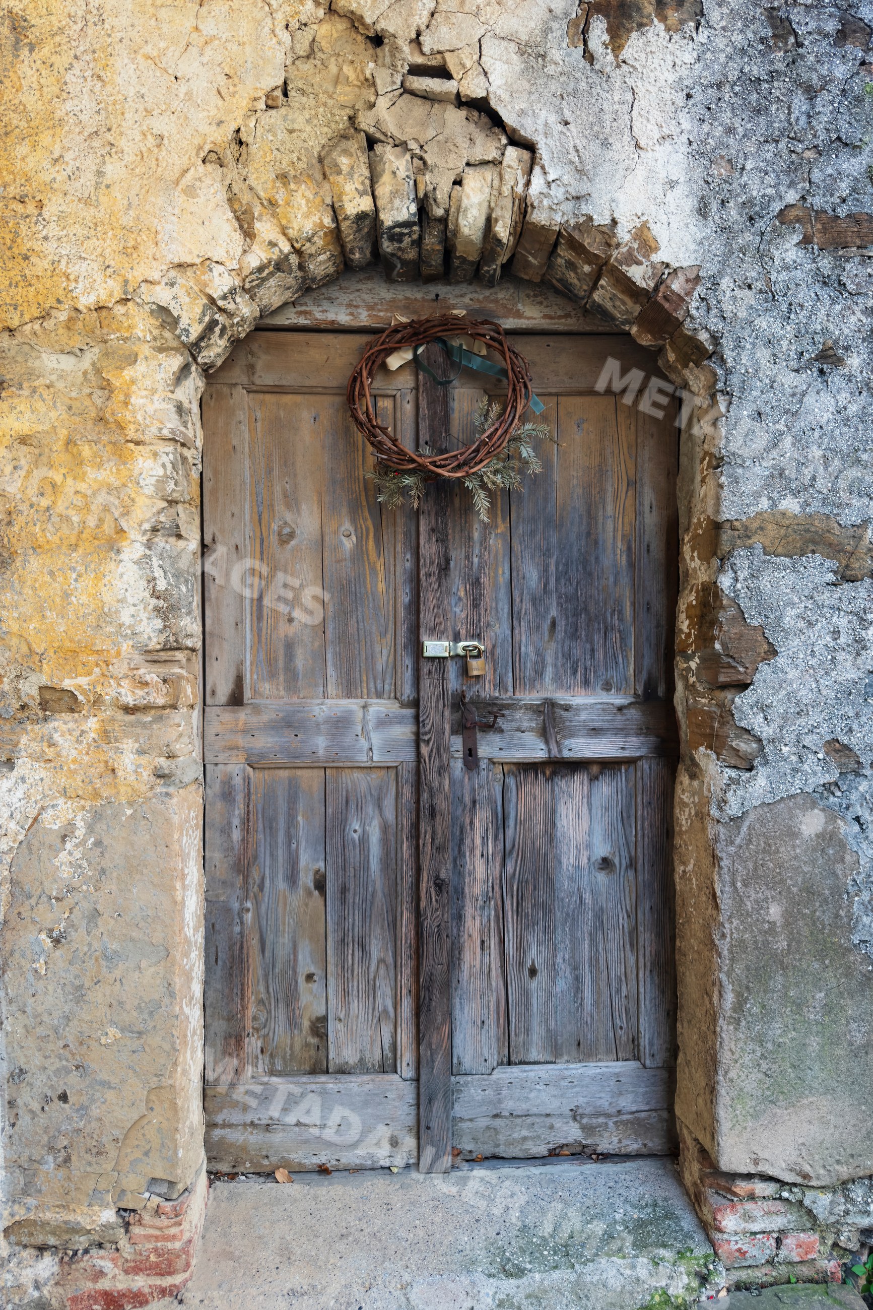 Rustic wooden door with wreath in stone archway in smartno Slovenia