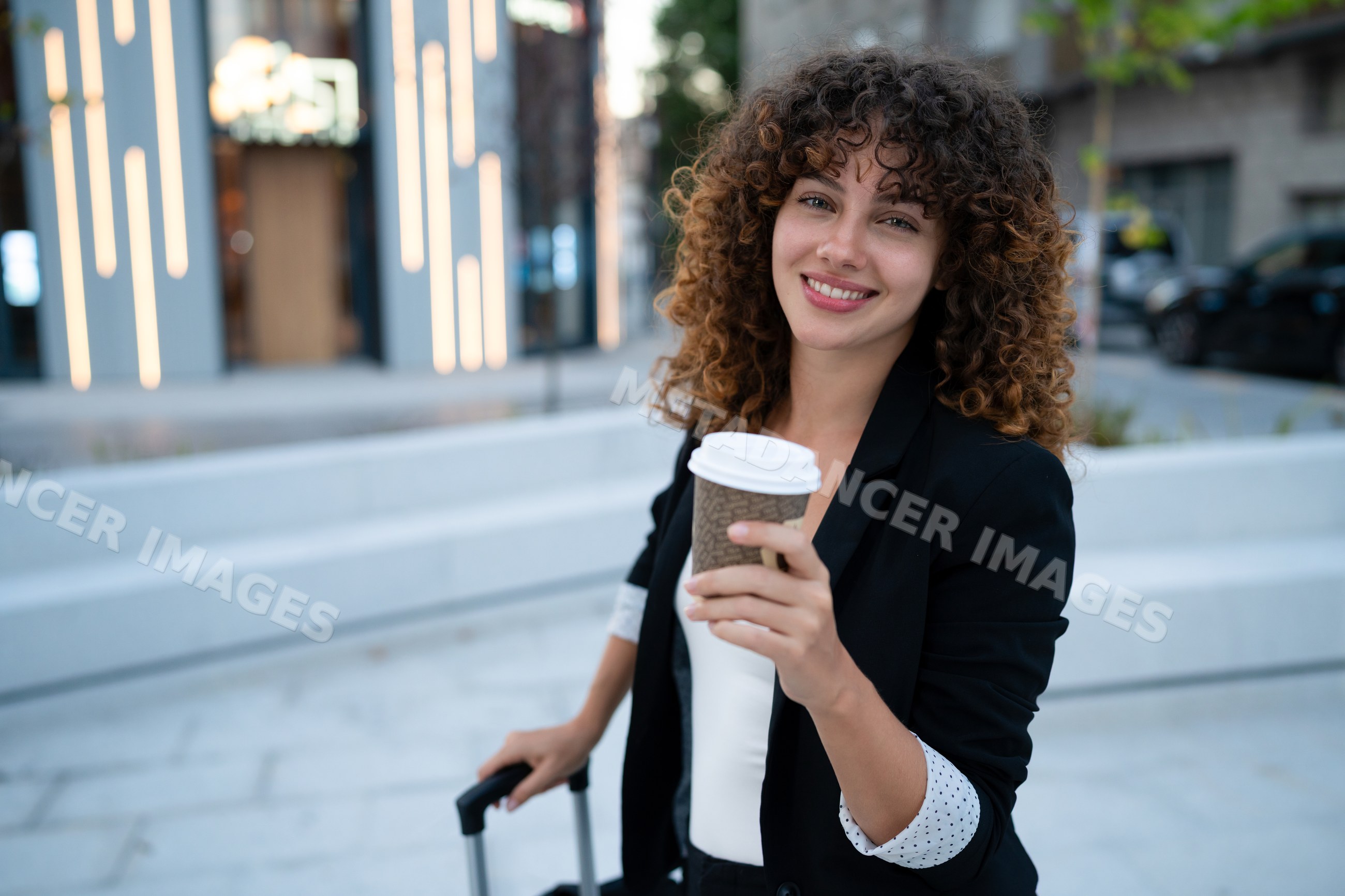 Young white woman holding to go coffee cup outdoors