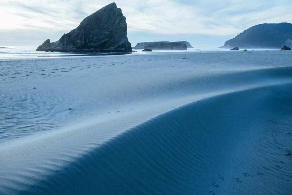 Beach with sand dunes and rock formations on Oregon coast