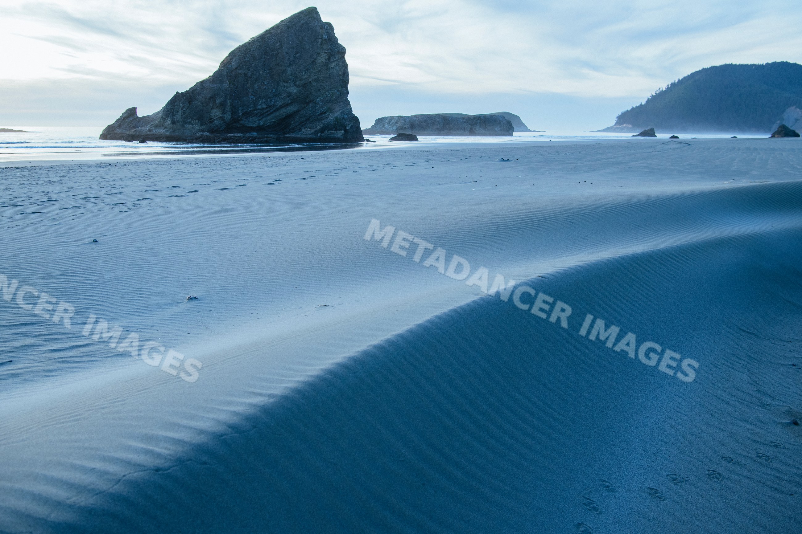 Beach with sand dunes and rock formations on Oregon coast