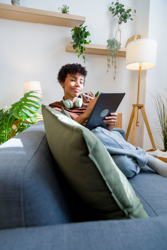 African American woman using tablet in modern living room setting