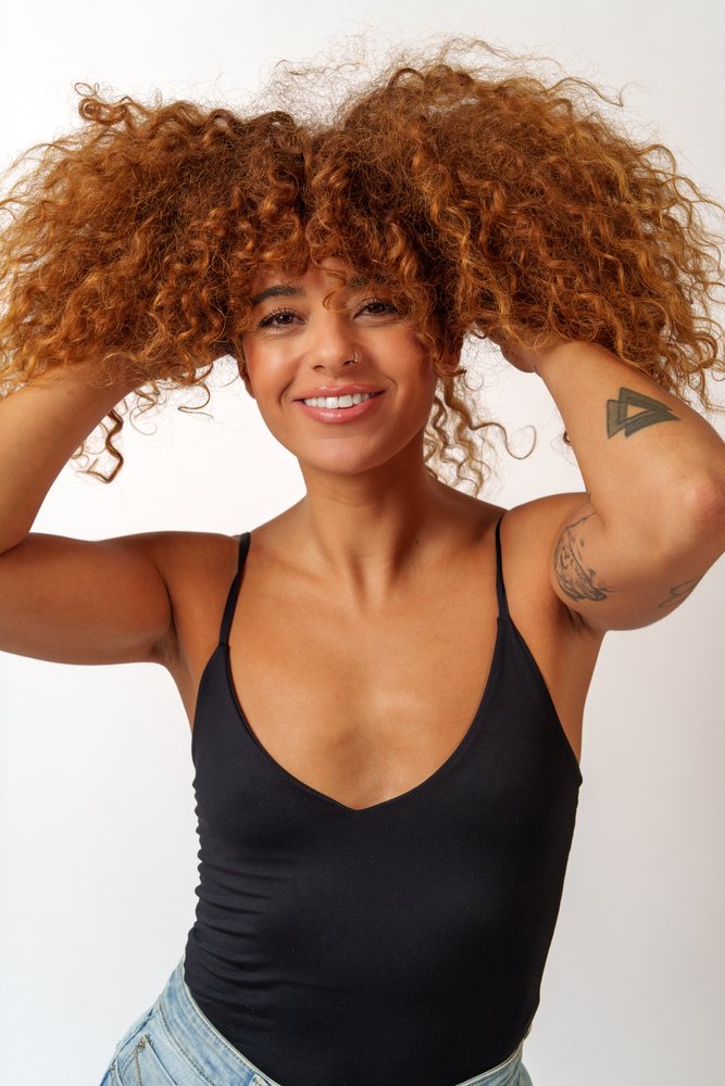 Hispanic woman smiling with curly red hair in studio in Malaga, Spain