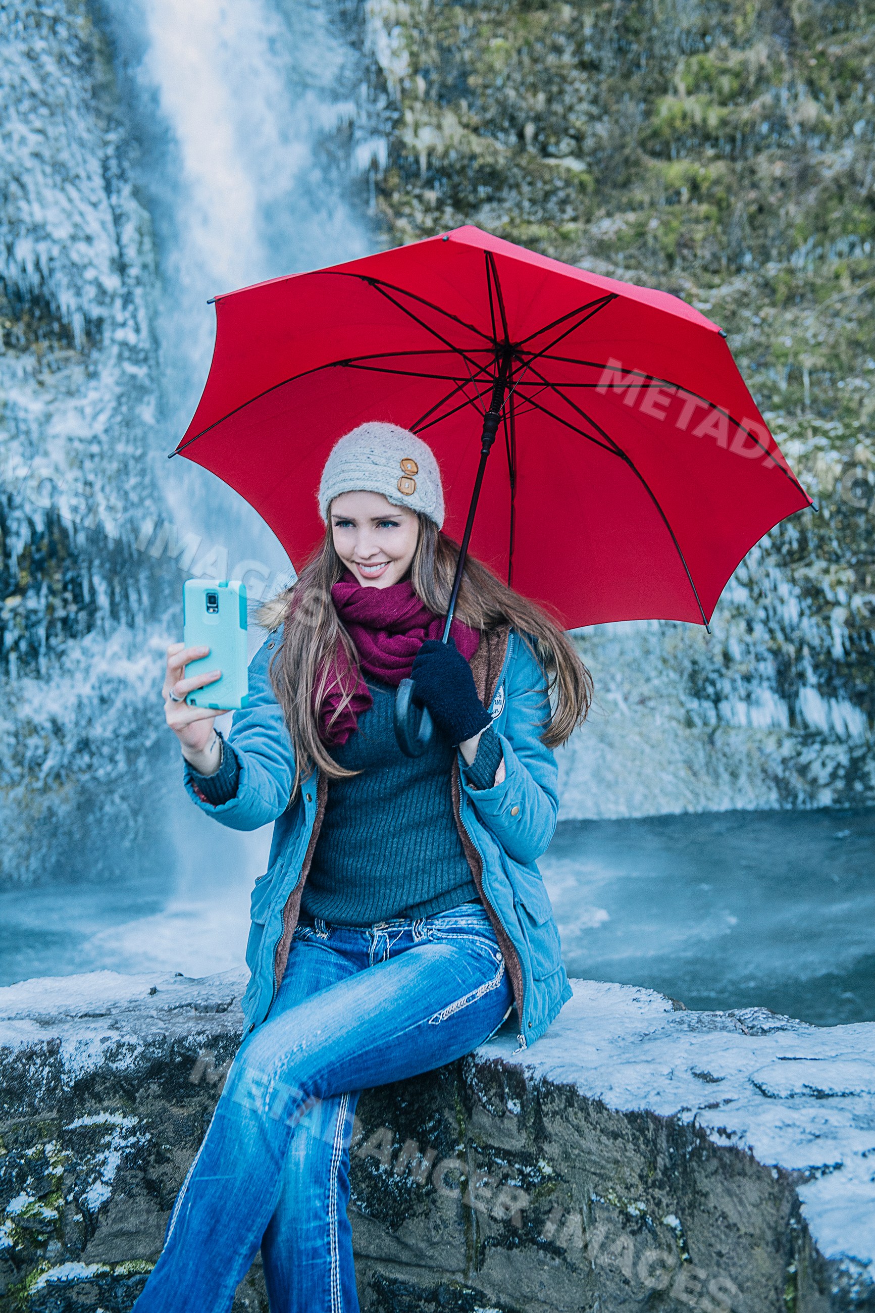 White woman with red umbrella taking selfie