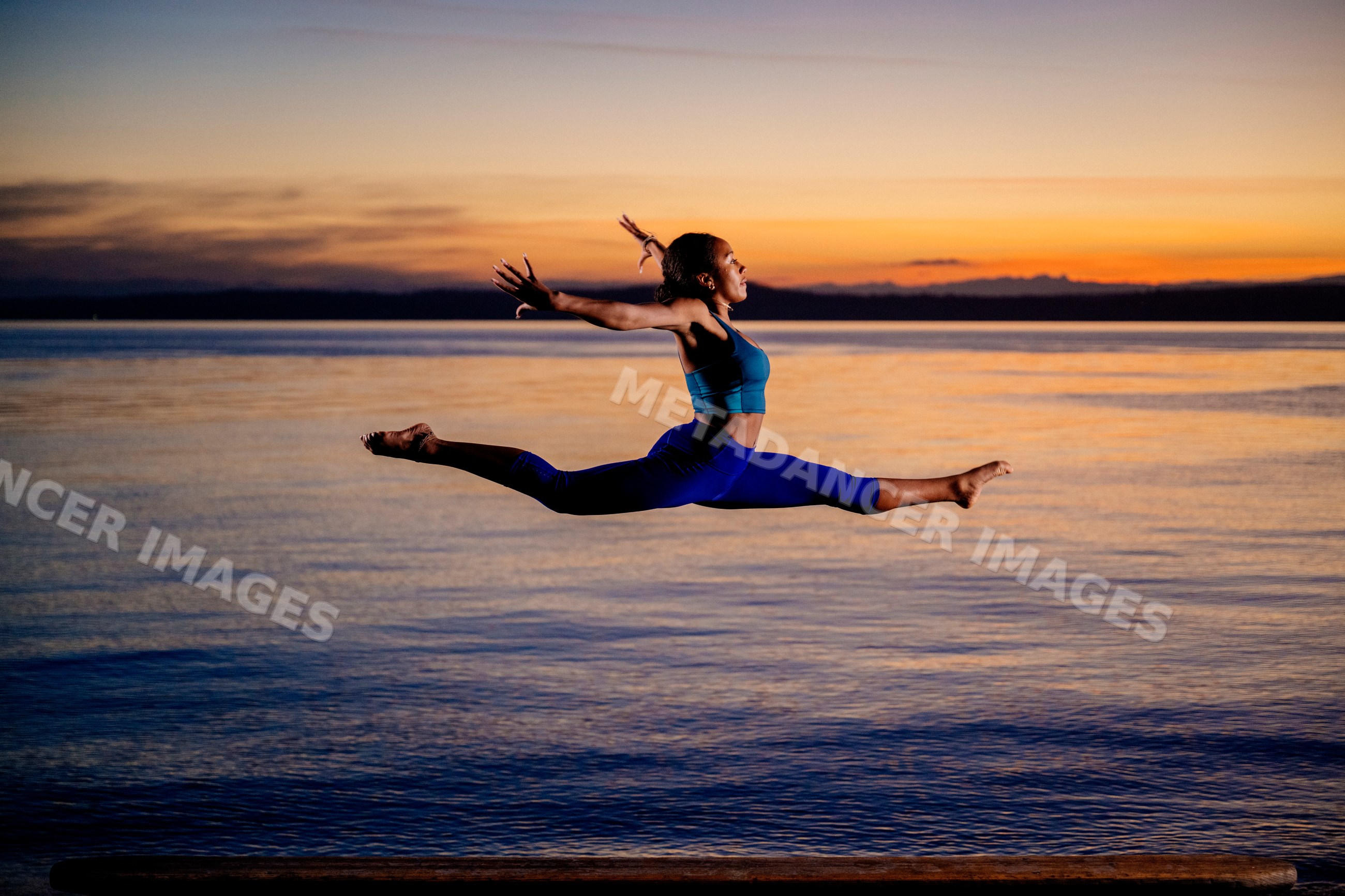 Hispanic woman performing acrobatic split jump exercise
