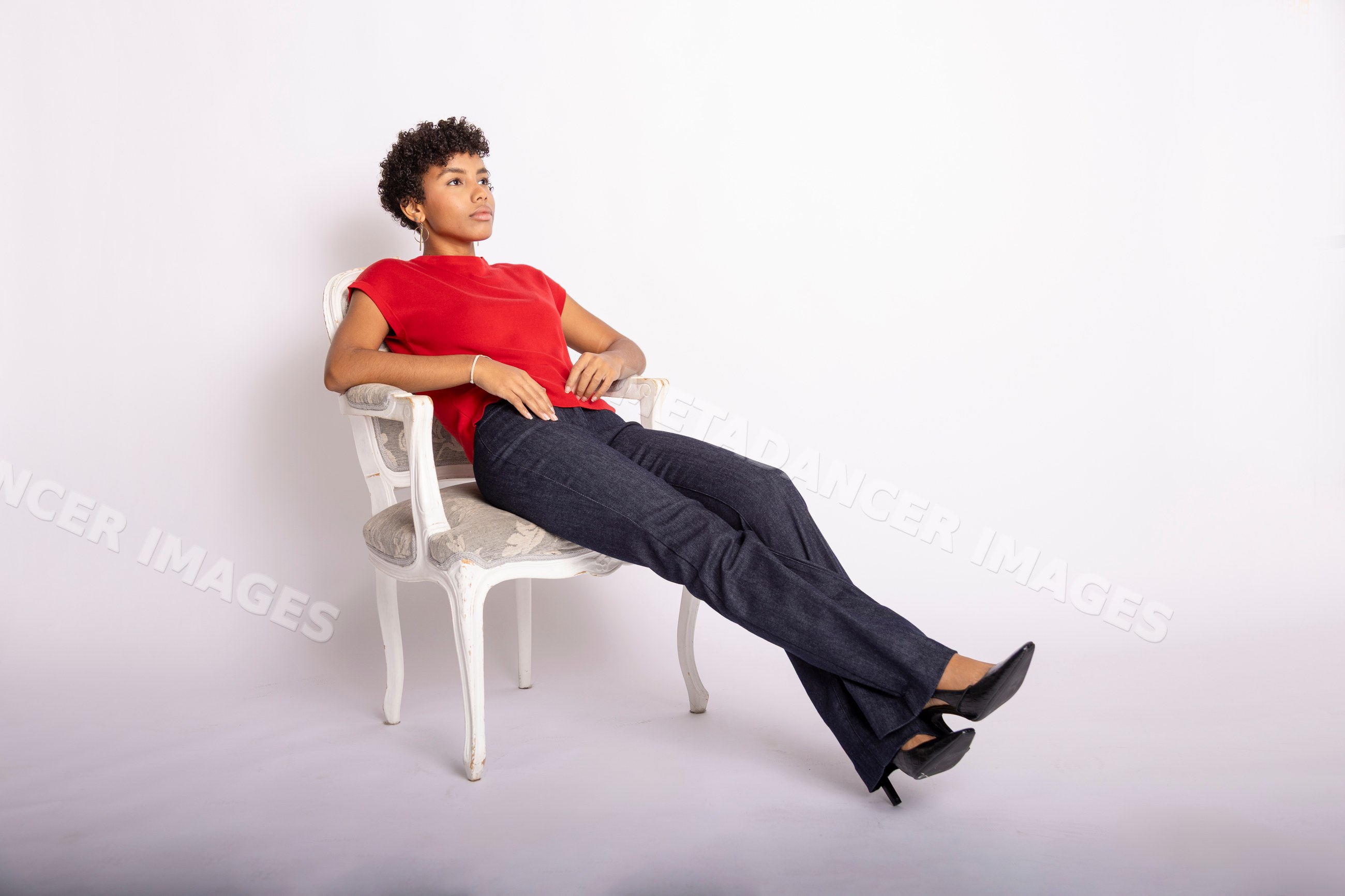 Young Hispanic woman sitting on white armchair