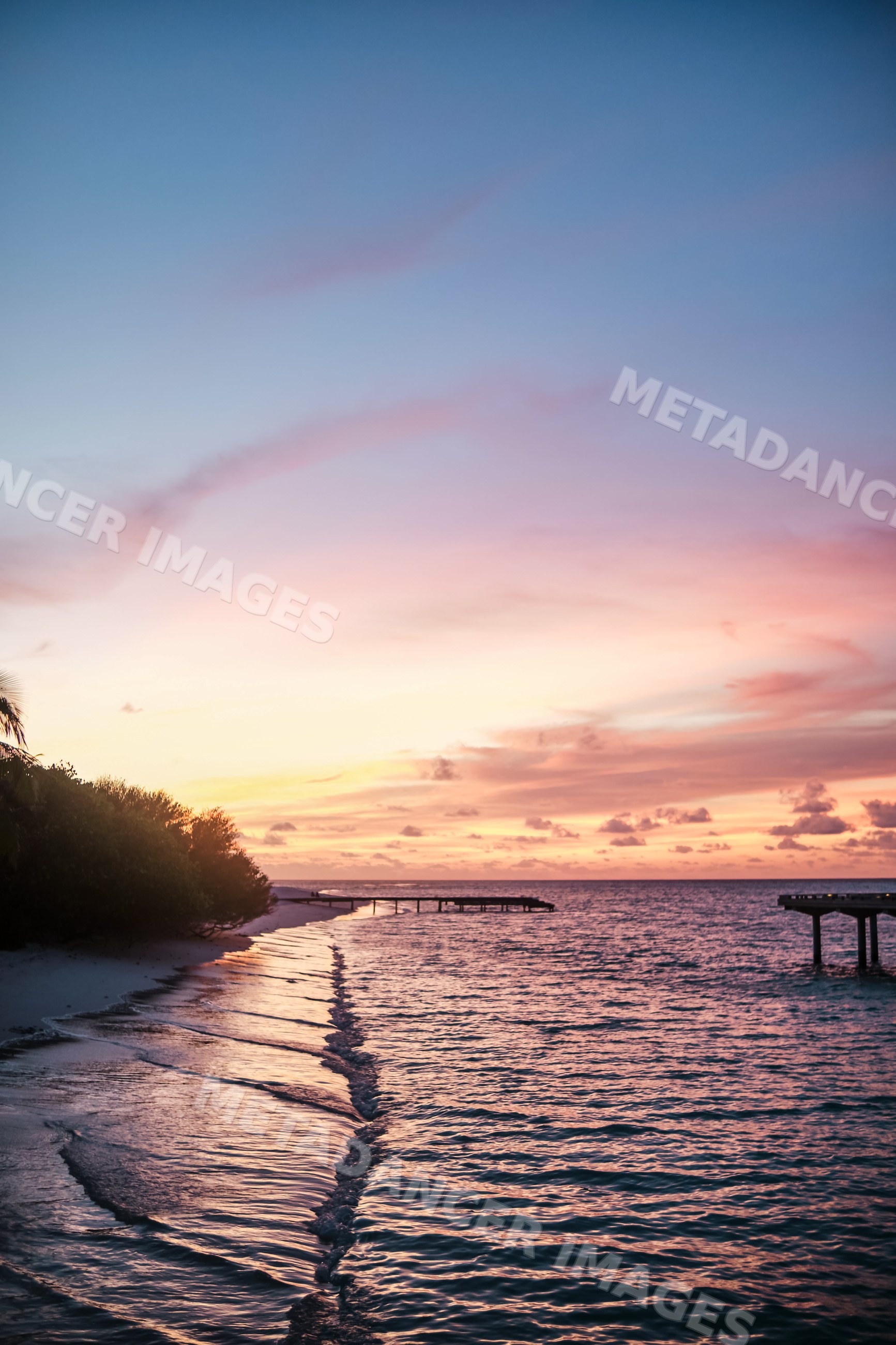 A tranquil sunset over a beach with waves and piers in a beach