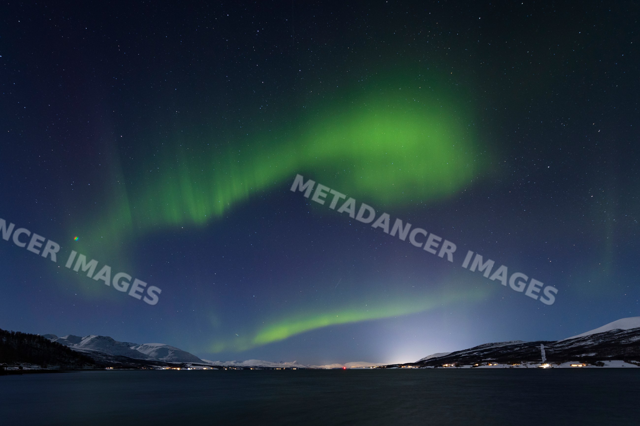 Northern Lights over snowy mountains and fjord