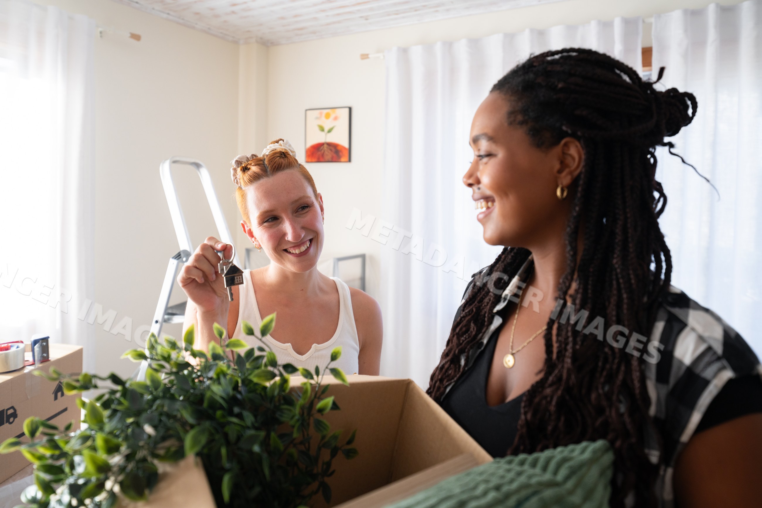 Two African American women happily moving into a new home