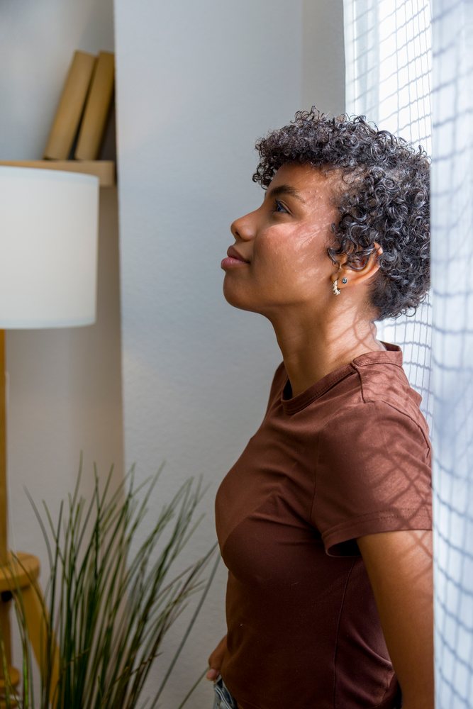 Young African American woman with curly hair relaxing indoors