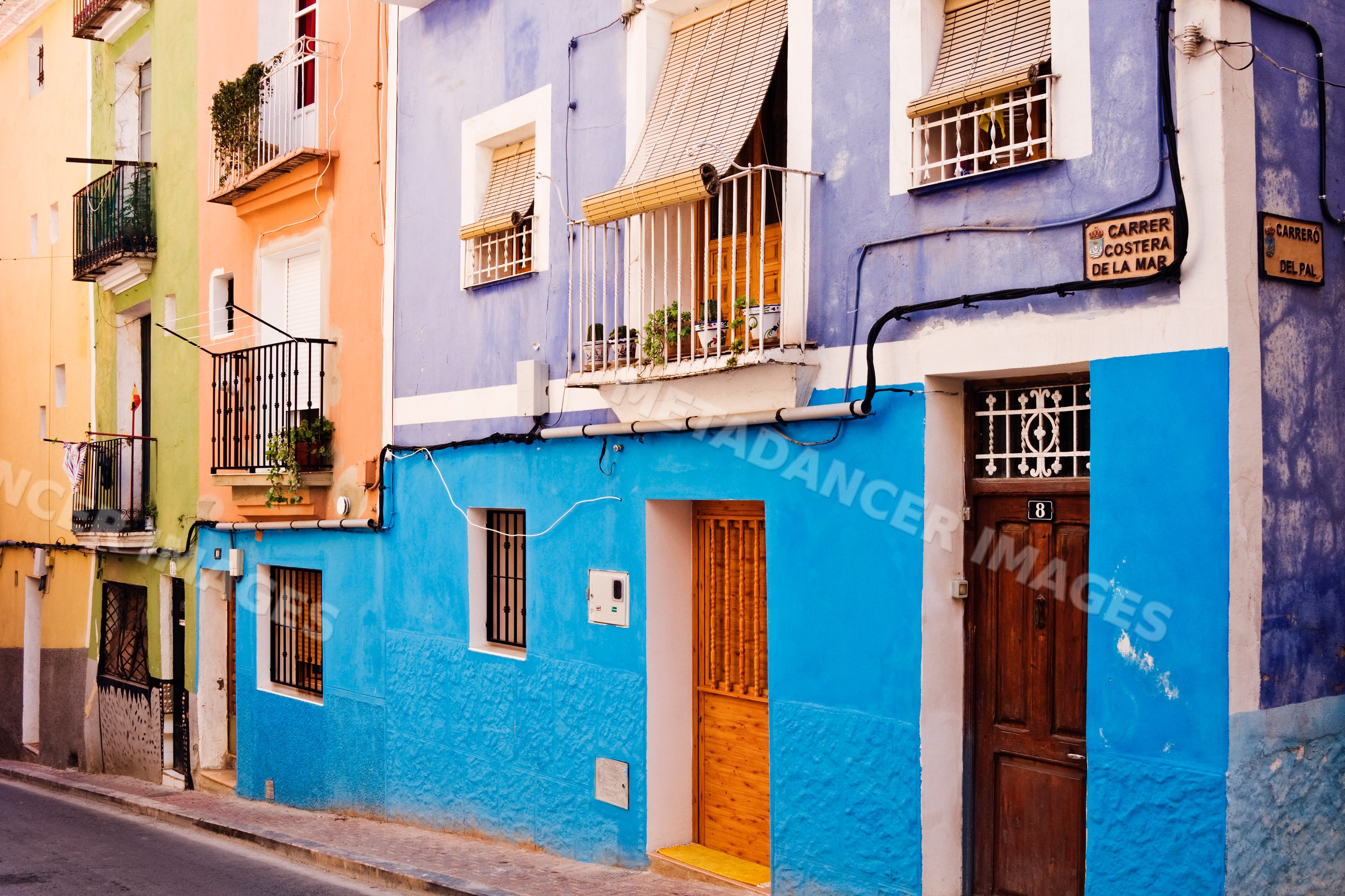 Colorful buildings with balconies on a street corner, Spain