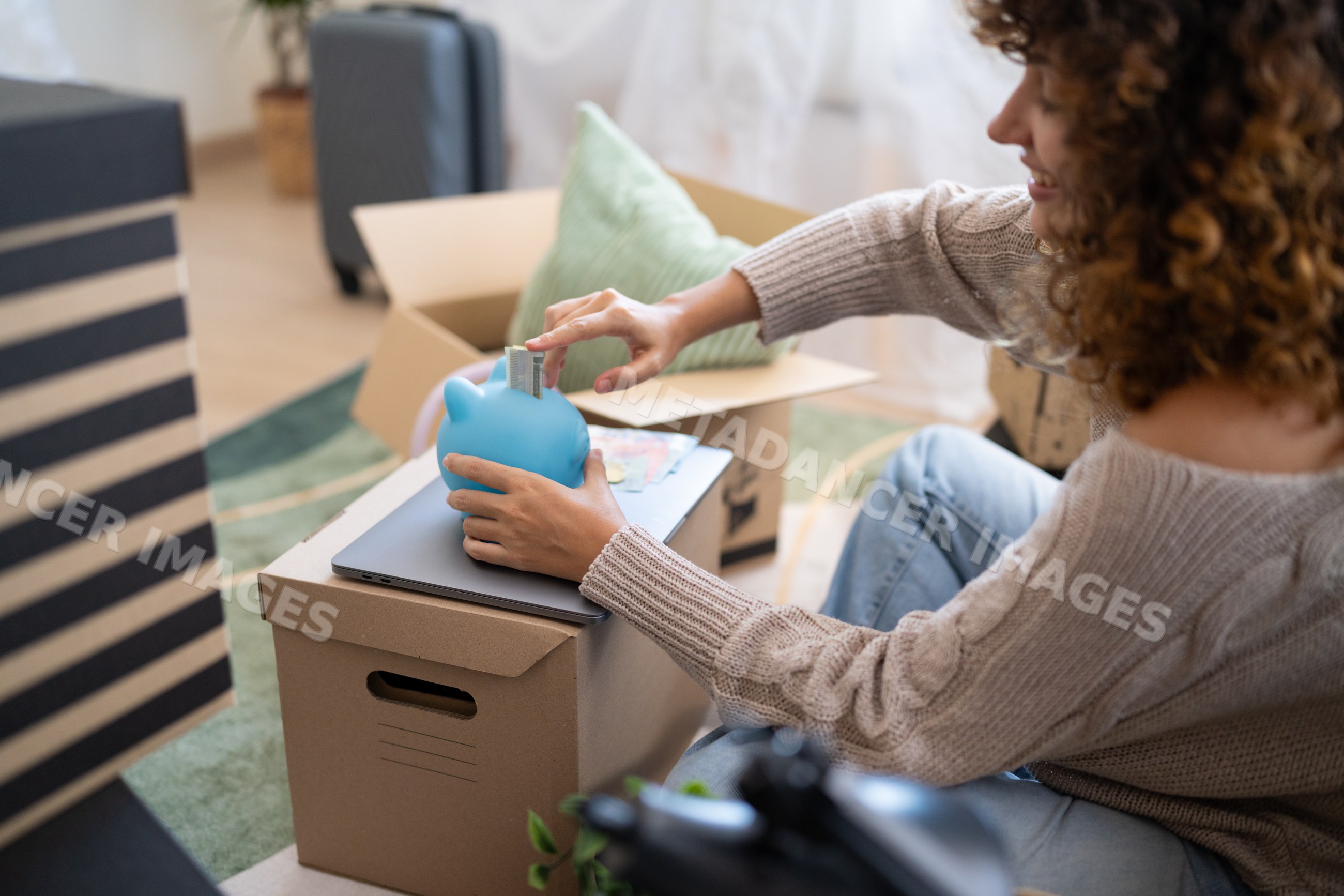 White woman saving money with piggy bank during home move