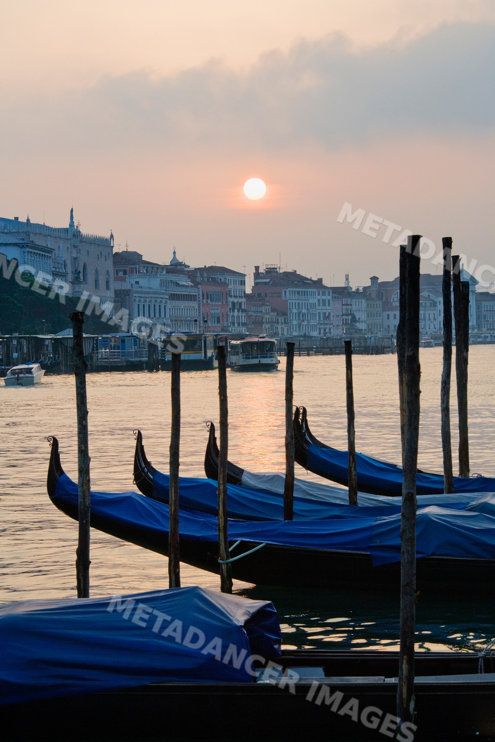 Gondolas moored on canal at sunset in venice italy