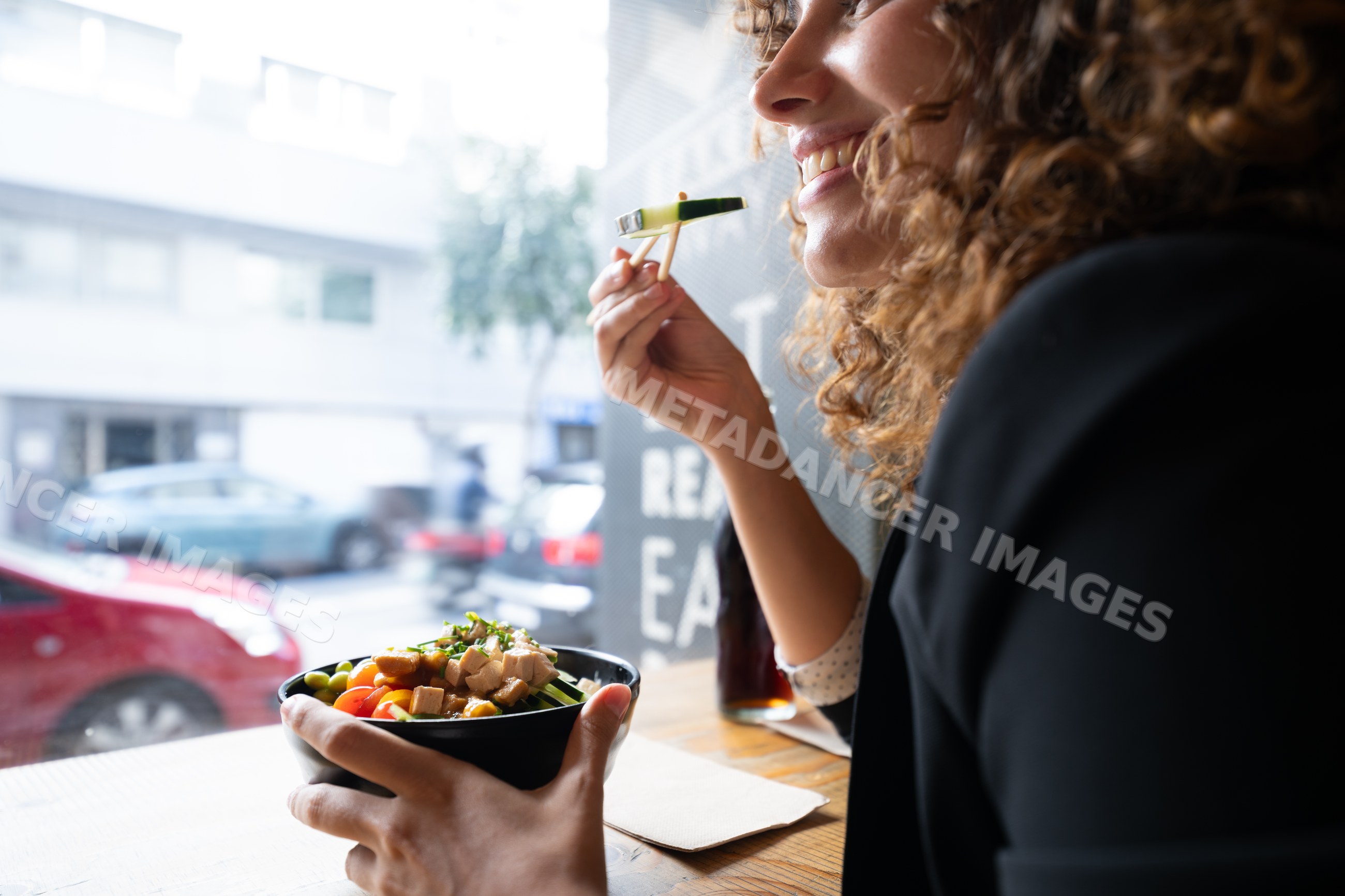 White woman enjoying a healthy bowl meal in an urban cafe