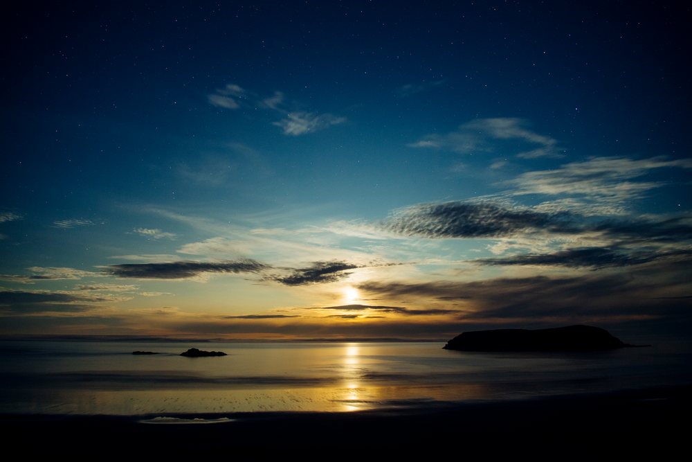 Sunset over sea with island and reflective water