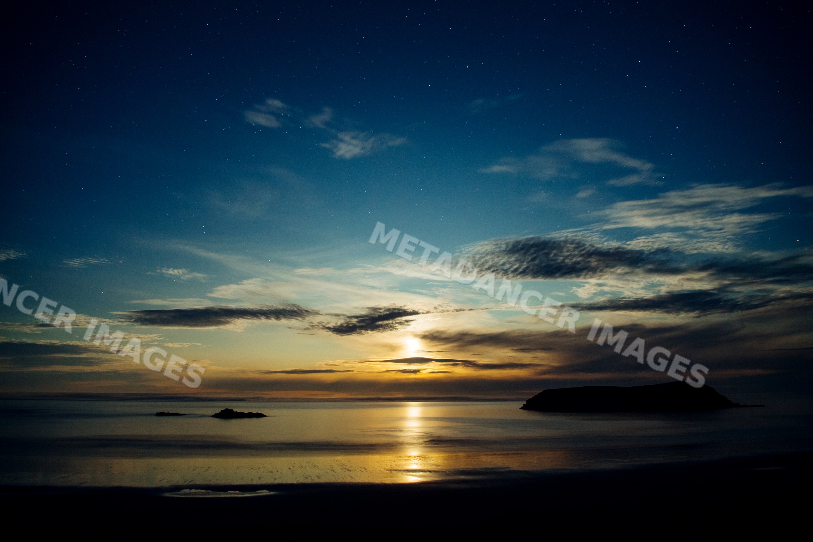 Sunset over sea with island and reflective water