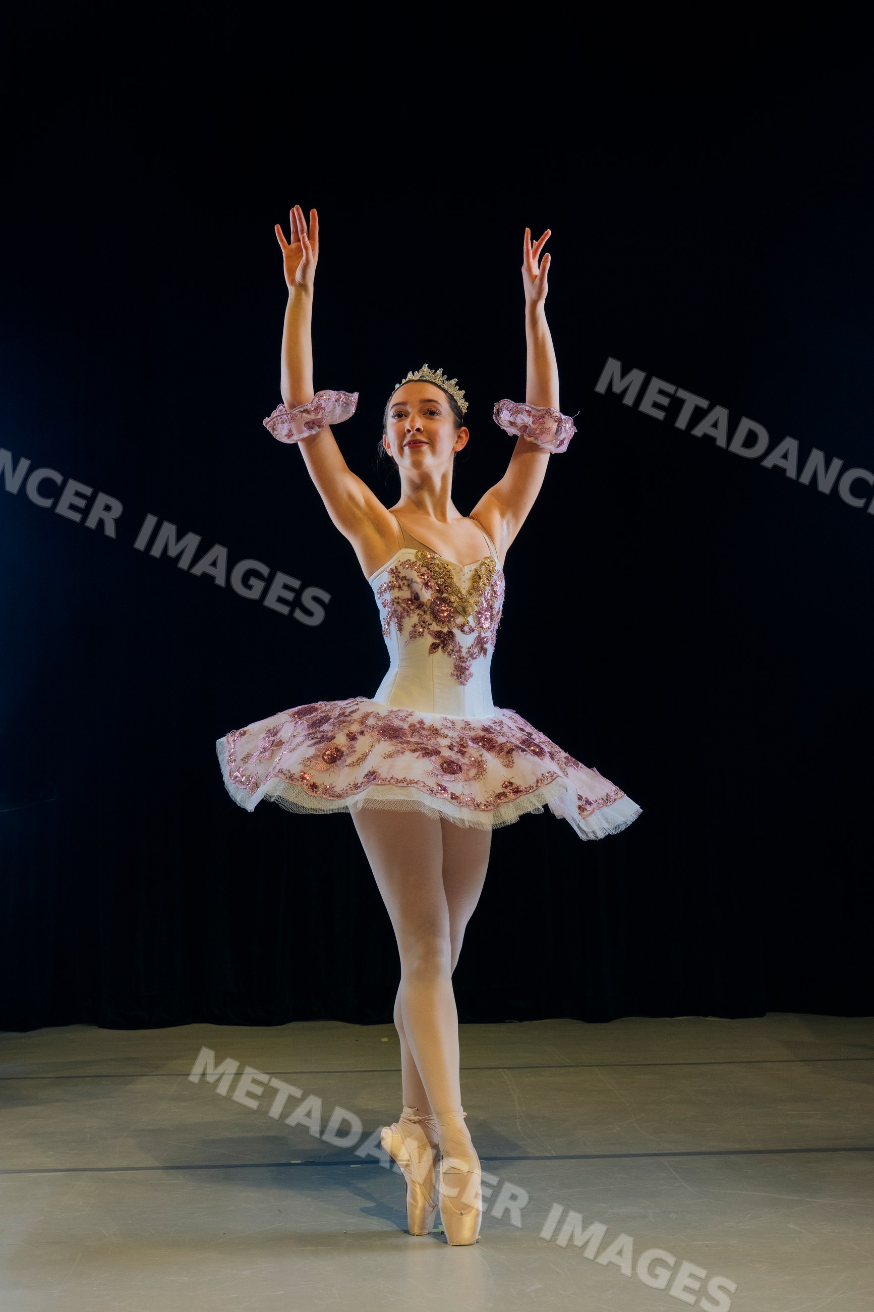 A ballerina performs a classical ballet pose during a stage production