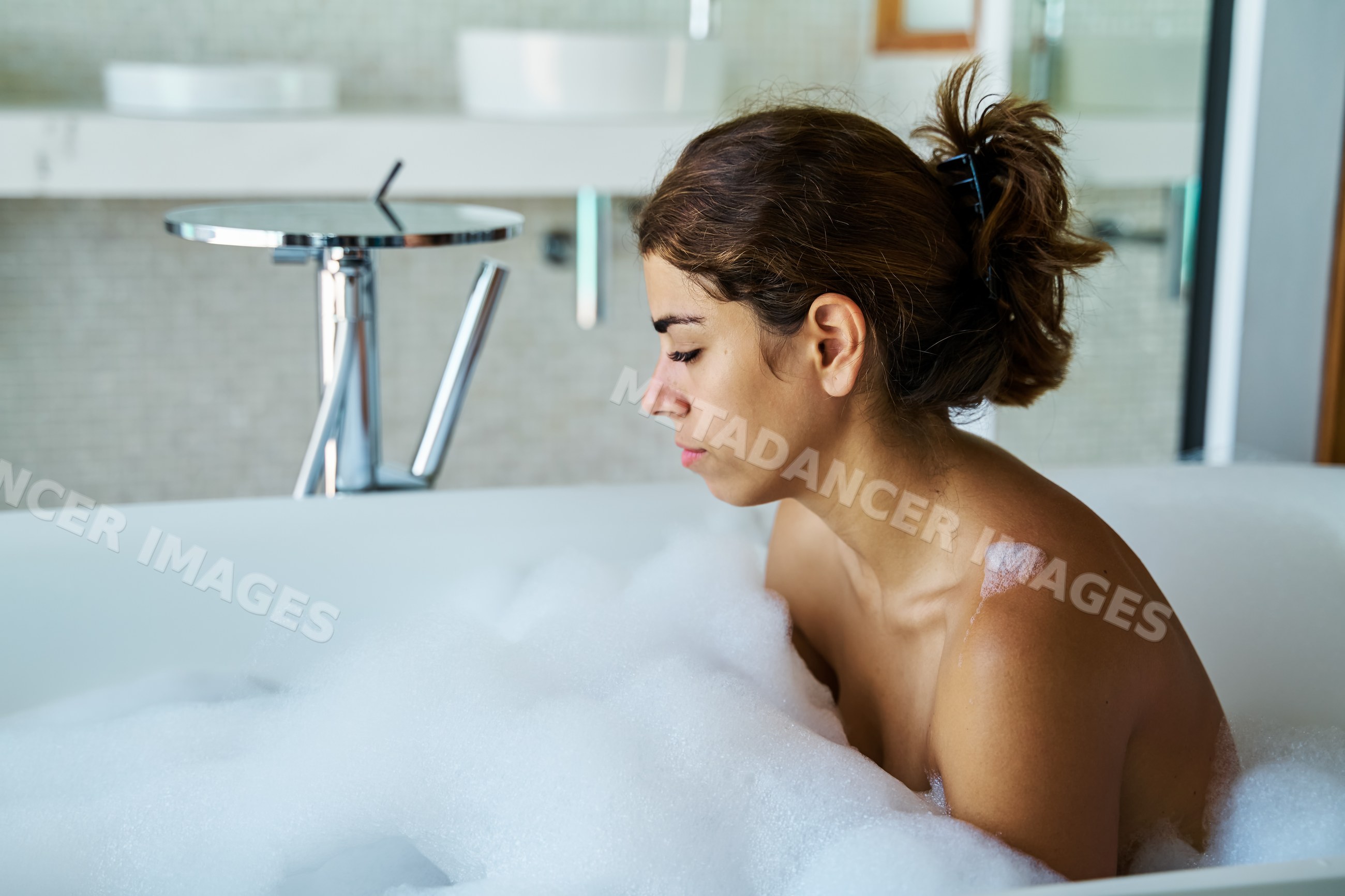 A white woman enjoys a relaxing bubble bath