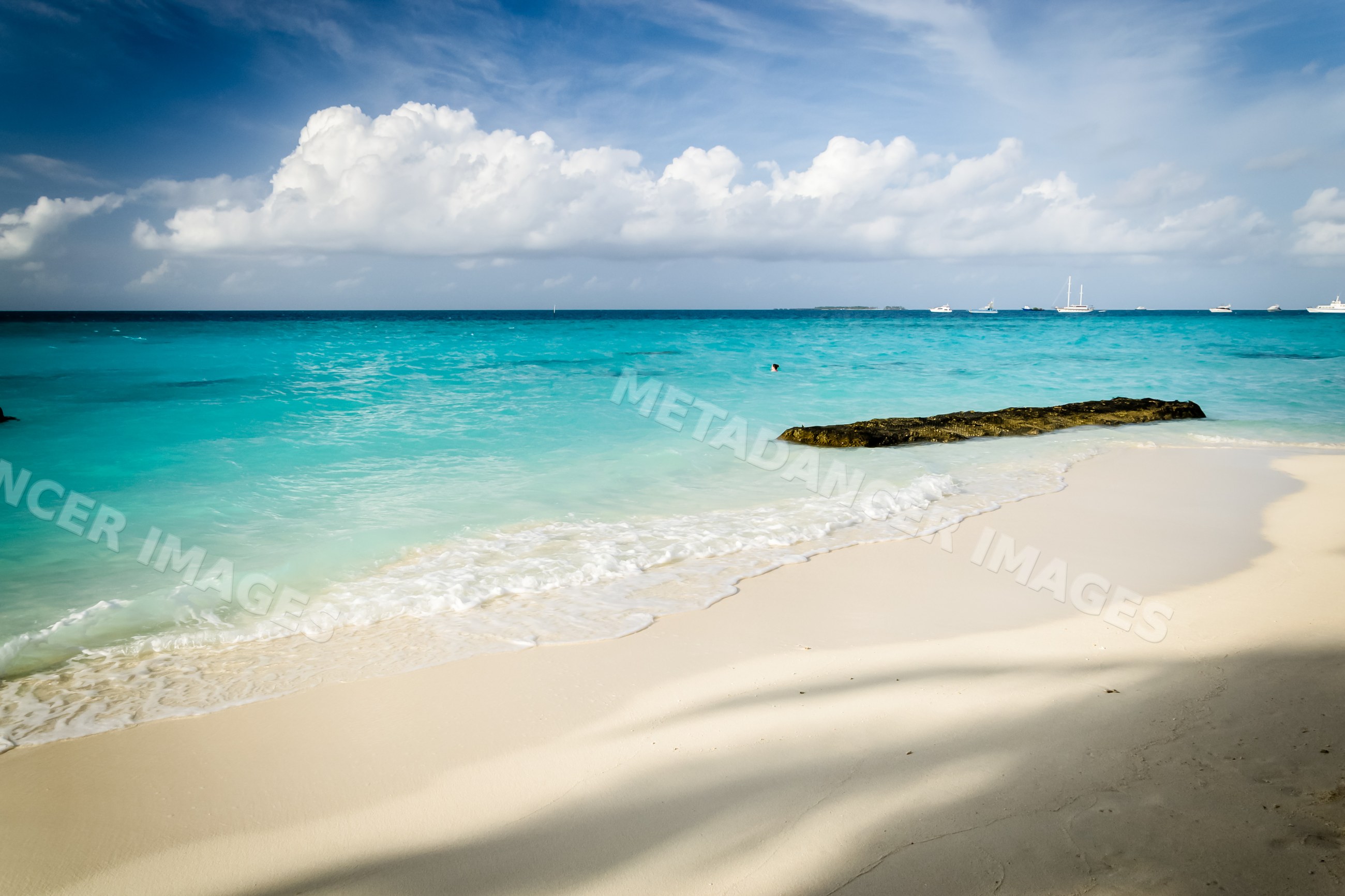 Beach shore with turquoise ocean waves and sand in Maldives landscape