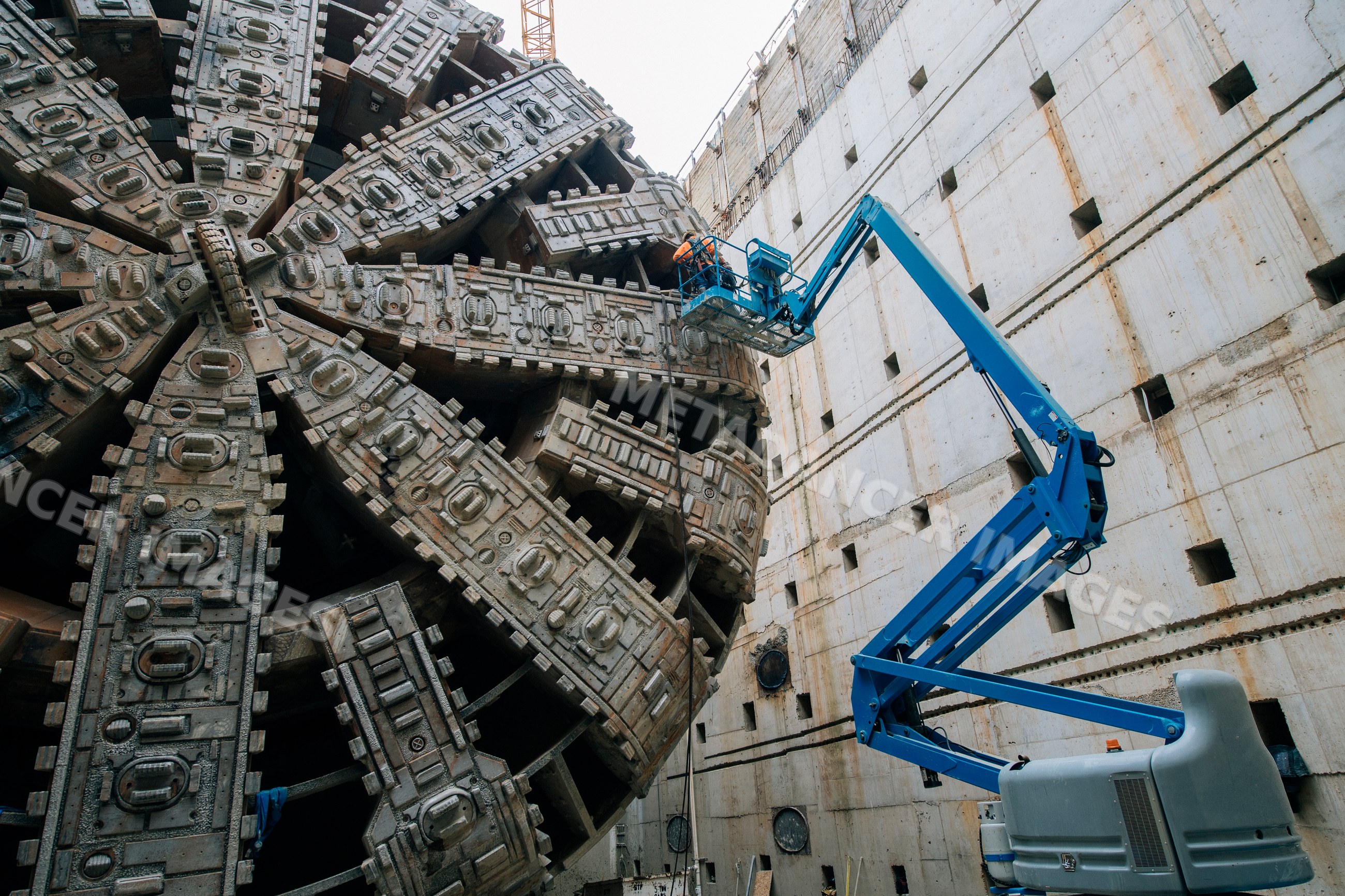 Construction worker inspects tunnel boring machine