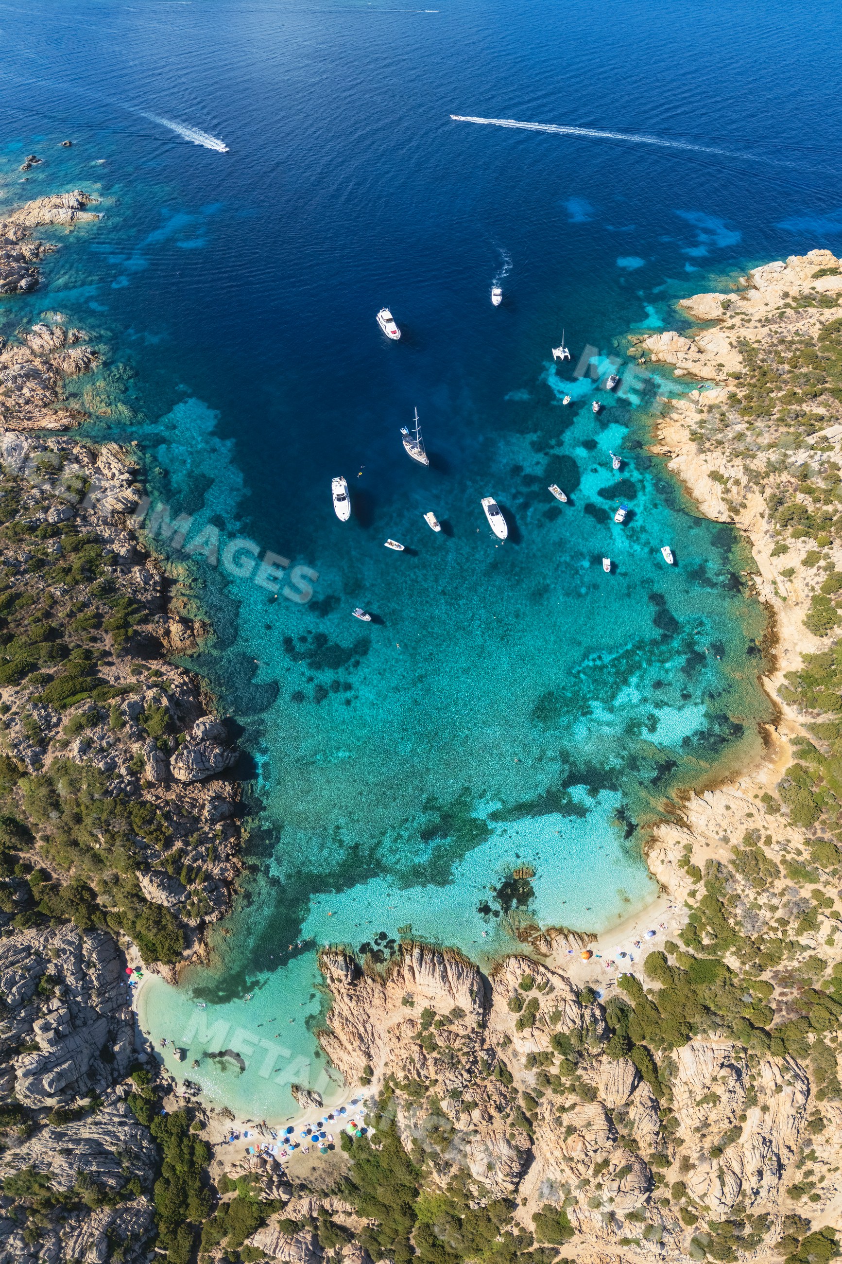 Cala Napolatana cove with boats in clear waters at la maddalena