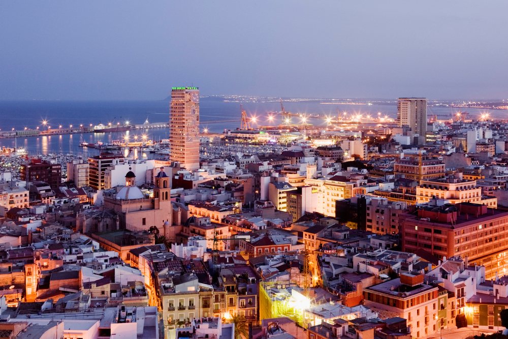Costa blanca cityscape with harbor cranes and evening lights