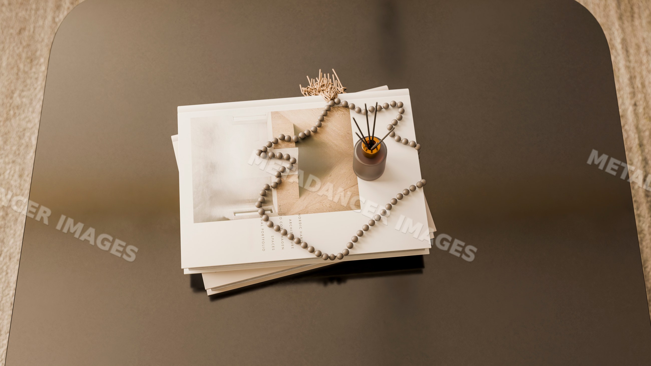 Stack of magazines with reed diffuser and beaded garland on table