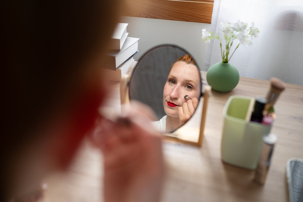 White Woman applying makeup at home in Galicia, Spain during working