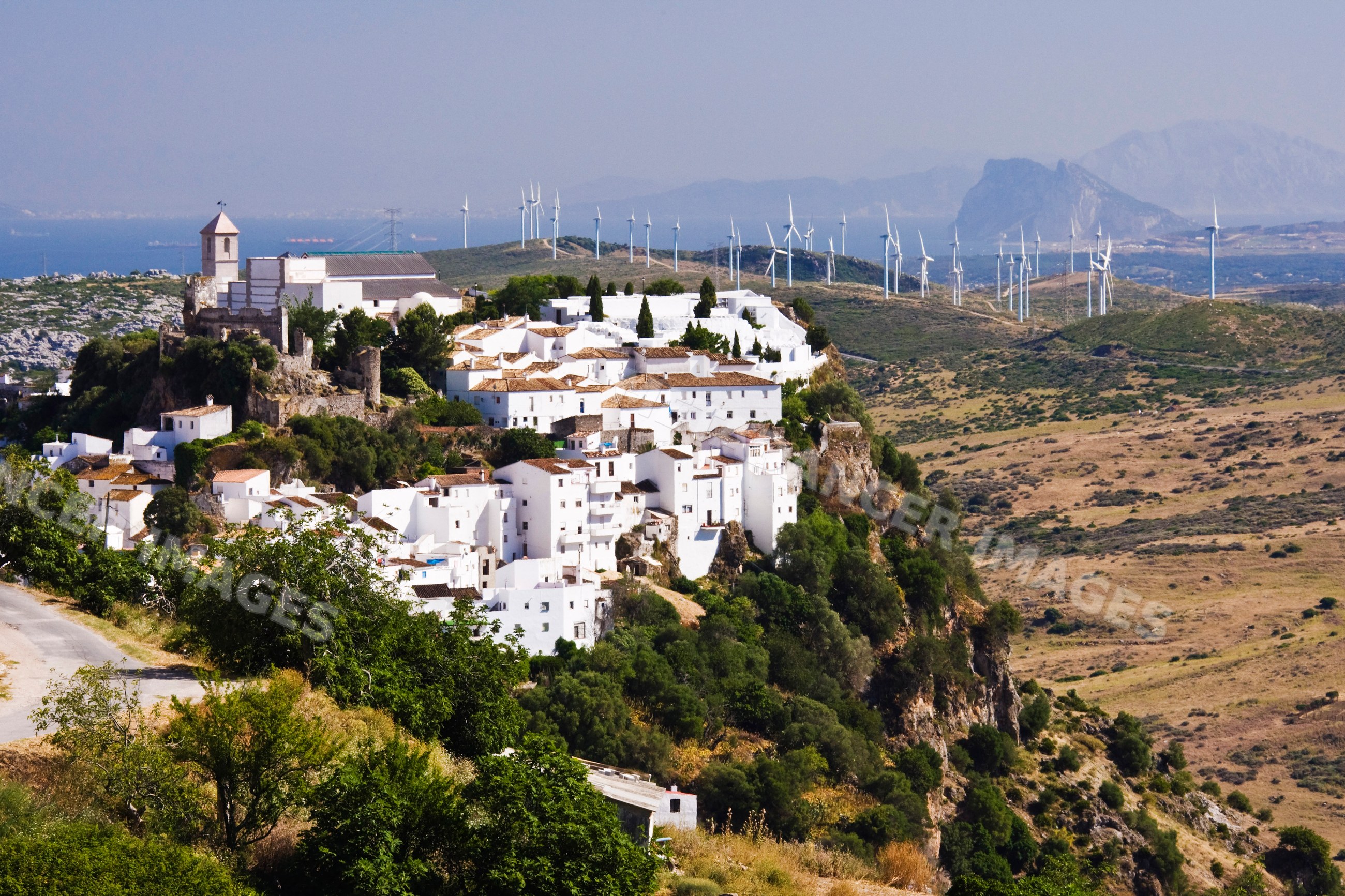 White hilltop village with wind turbines in rural andalucia Spain