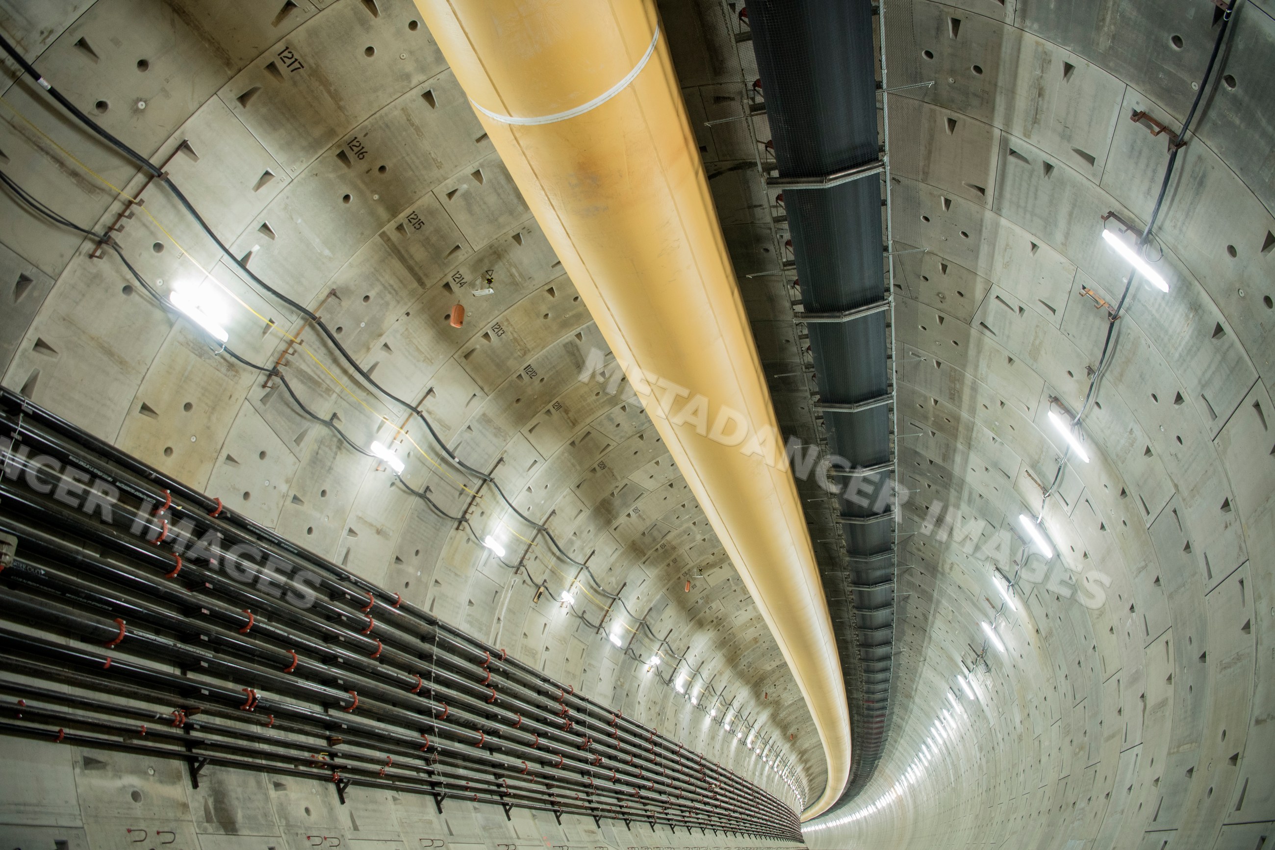 Inside a large round industrial tunnel with ventilation ducts