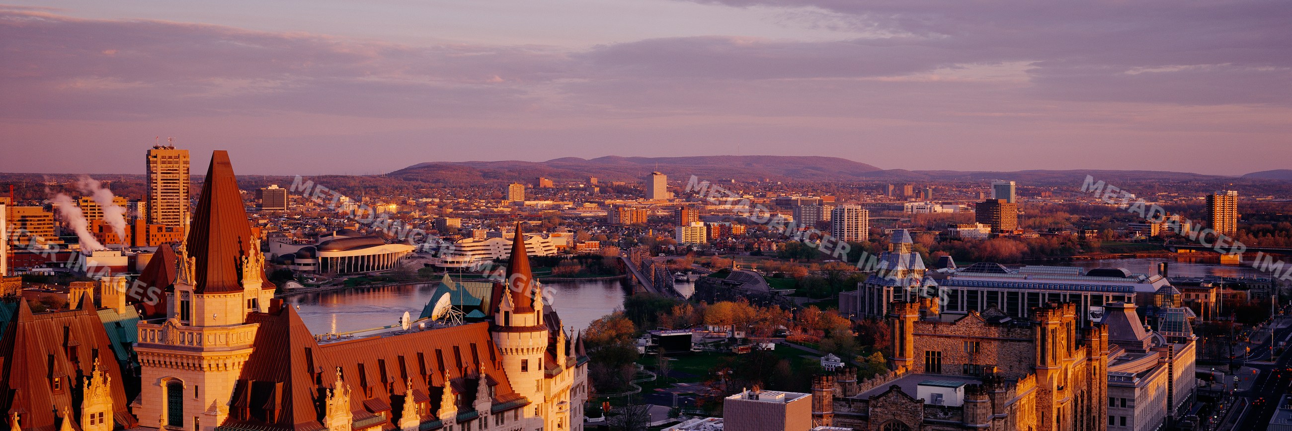 Cityscape with river, bridge, and urban buildings at sunset