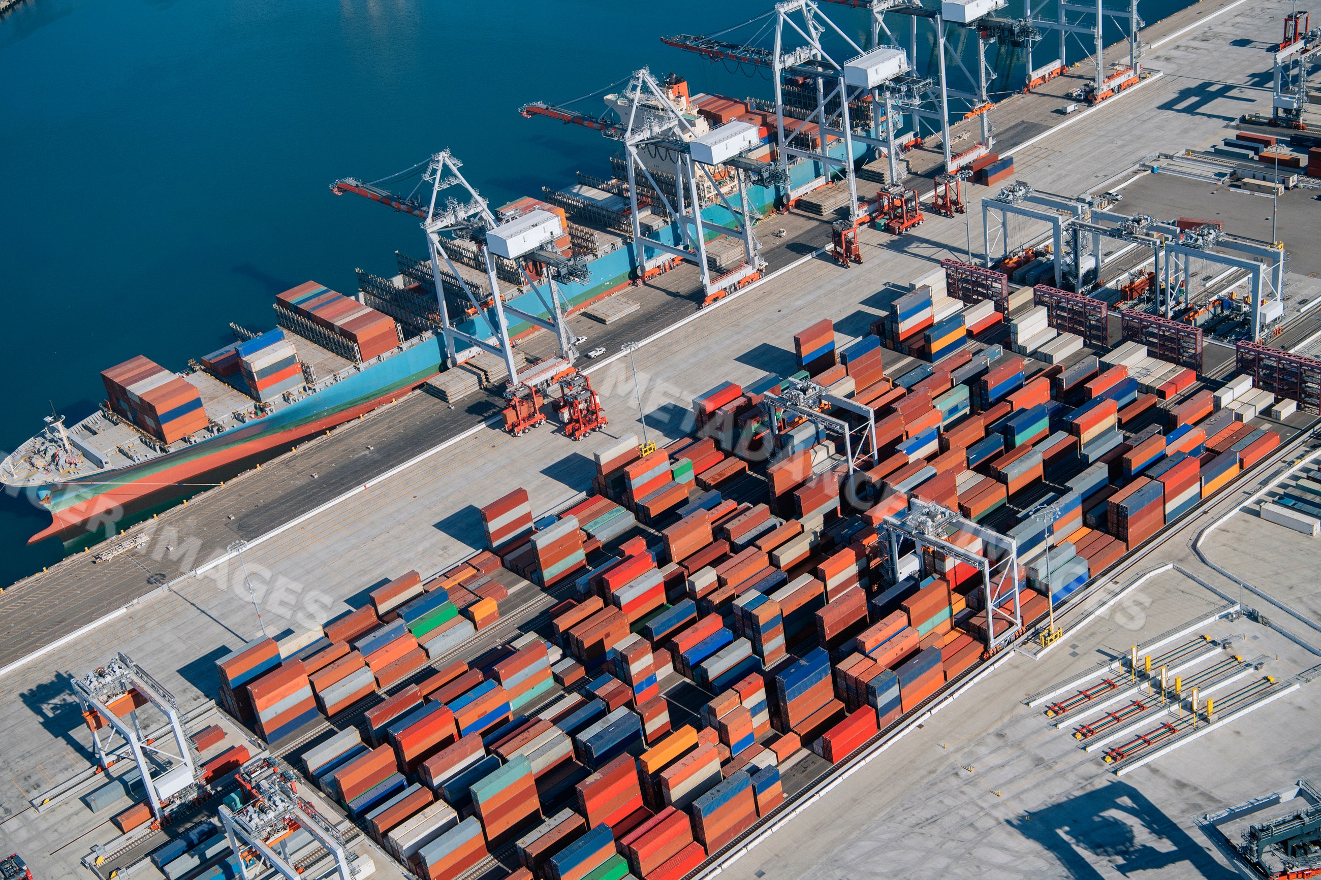 Container port with cargo ship and cranes in a beach