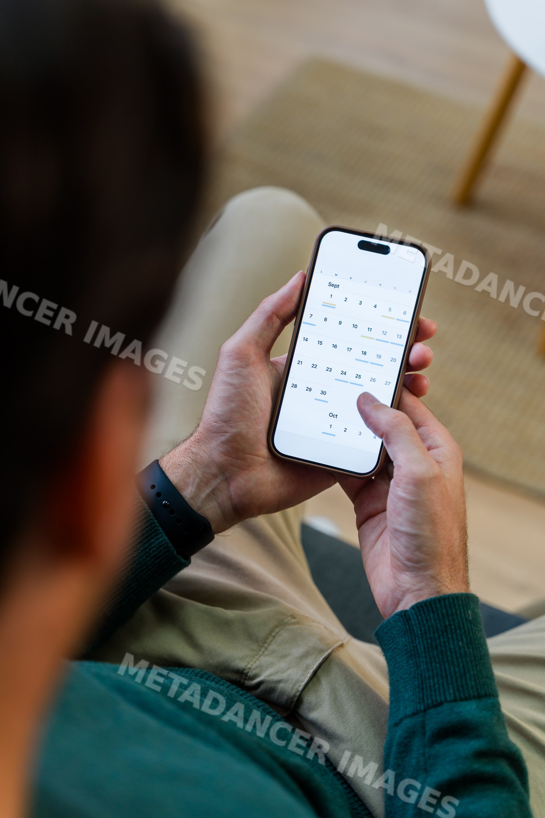 White man holding smartphone with calendar app managing schedule